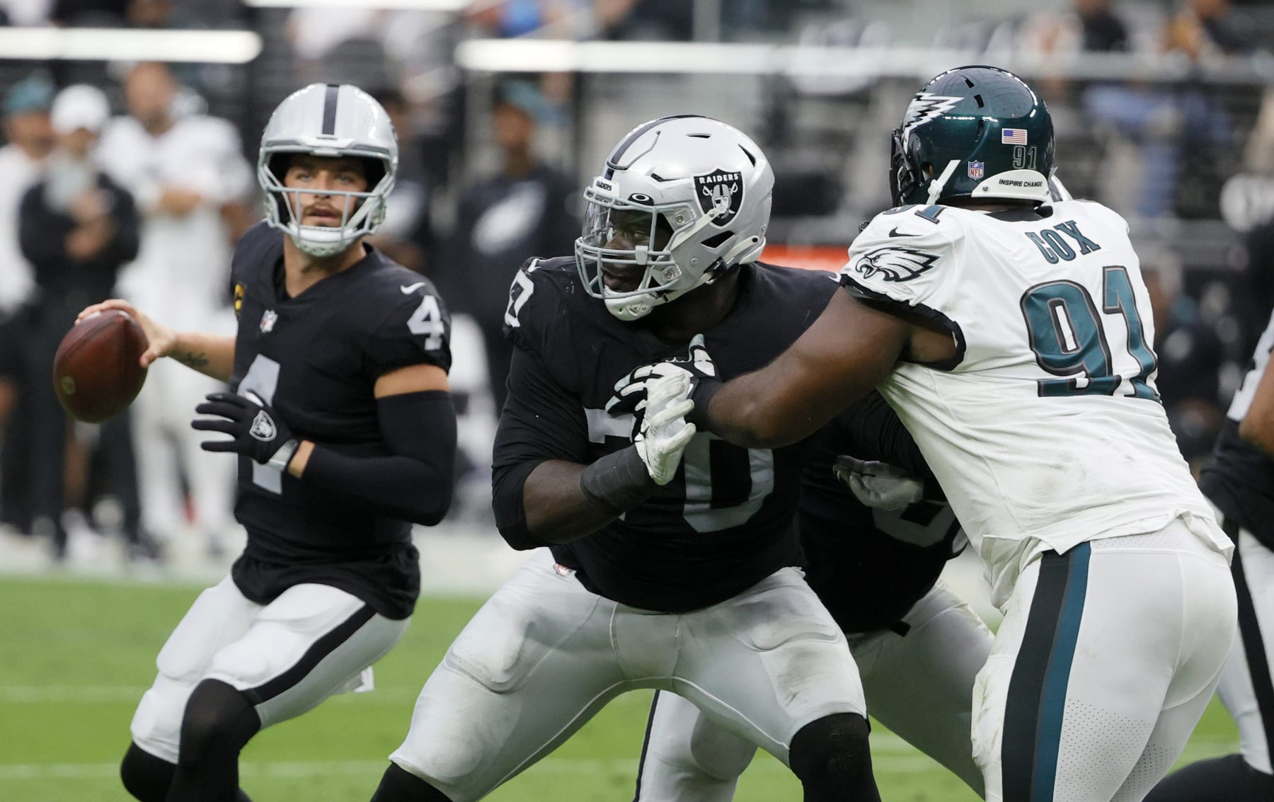 LAS VEGAS, NEVADA - OCTOBER 24:  Offensive tackle Alex Leatherwood #70 of the Las Vegas Raiders blocks defensive tackle Fletcher Cox #91 of the Philadelphia Eagles in front of quarterback Derek Carr #4 of the Raiders during their game at Allegiant Stadium on October 24, 2021 in Las Vegas, Nevada. The Raiders defeated the Eagles 33-22.  (Photo by Ethan Miller/Getty Images)