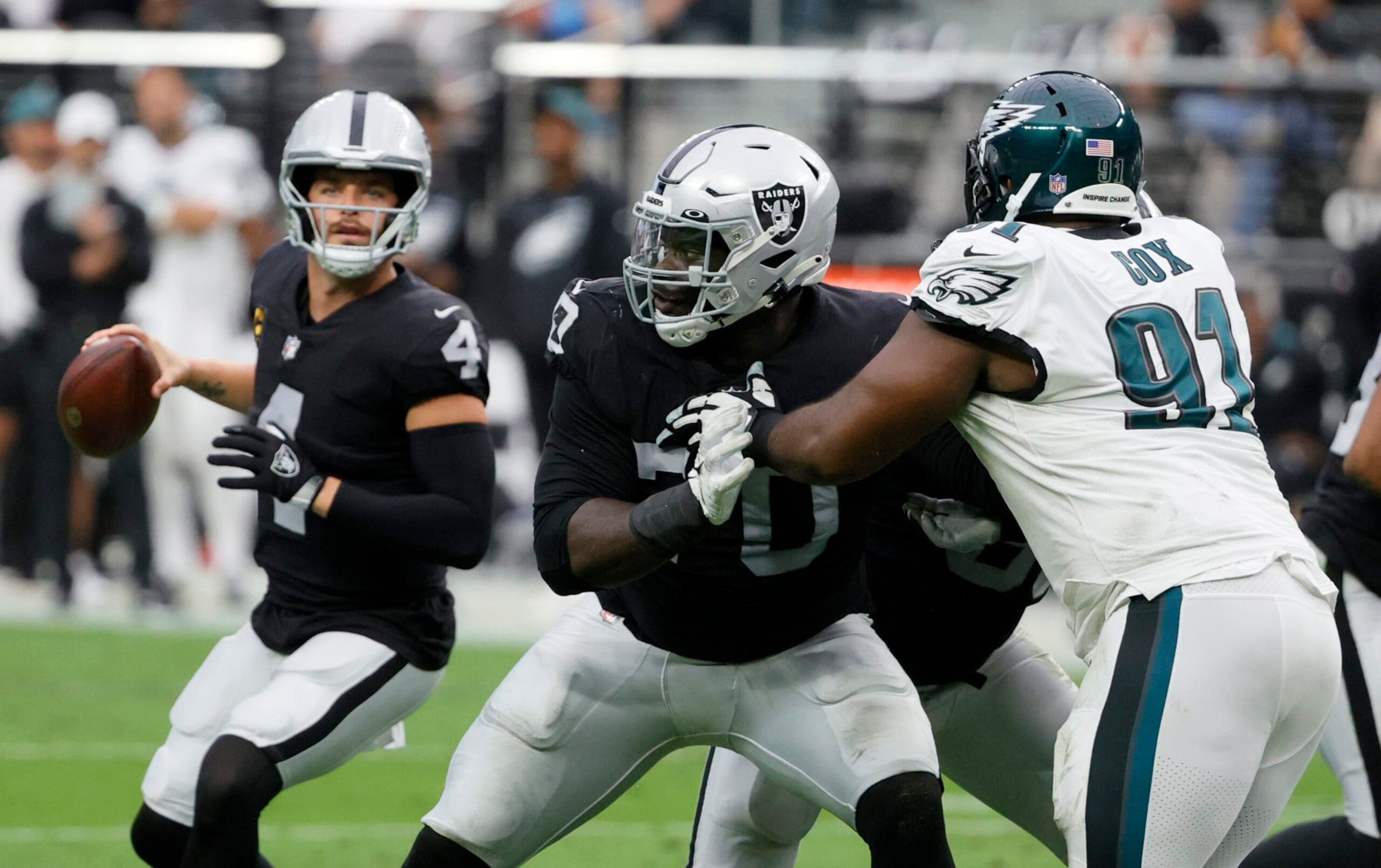 LAS VEGAS, NEVADA - OCTOBER 24:  Offensive tackle Alex Leatherwood #70 of the Las Vegas Raiders blocks defensive tackle Fletcher Cox #91 of the Philadelphia Eagles in front of quarterback Derek Carr #4 of the Raiders during their game at Allegiant Stadium on October 24, 2021 in Las Vegas, Nevada. The Raiders defeated the Eagles 33-22.  (Photo by Ethan Miller/Getty Images)