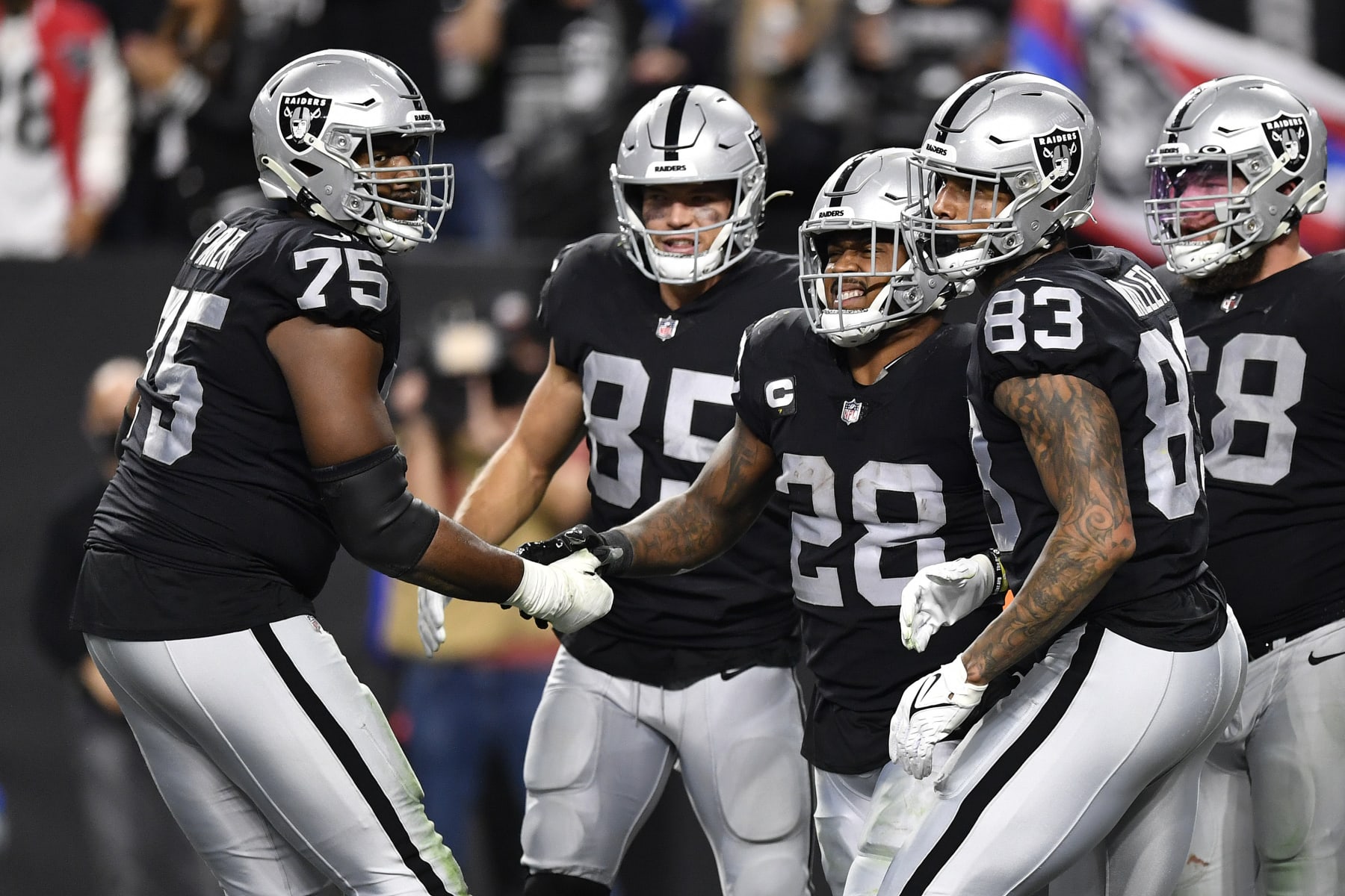 LAS VEGAS, NEVADA - JANUARY 09: Brandon Parker #75 and Josh Jacobs #28 of the Las Vegas Raiders celebrate a touchdown by Jacobs during the second quarter against the Los Angeles Chargers at Allegiant Stadium on January 09, 2022 in Las Vegas, Nevada. (Photo by Chris Unger/Getty Images)