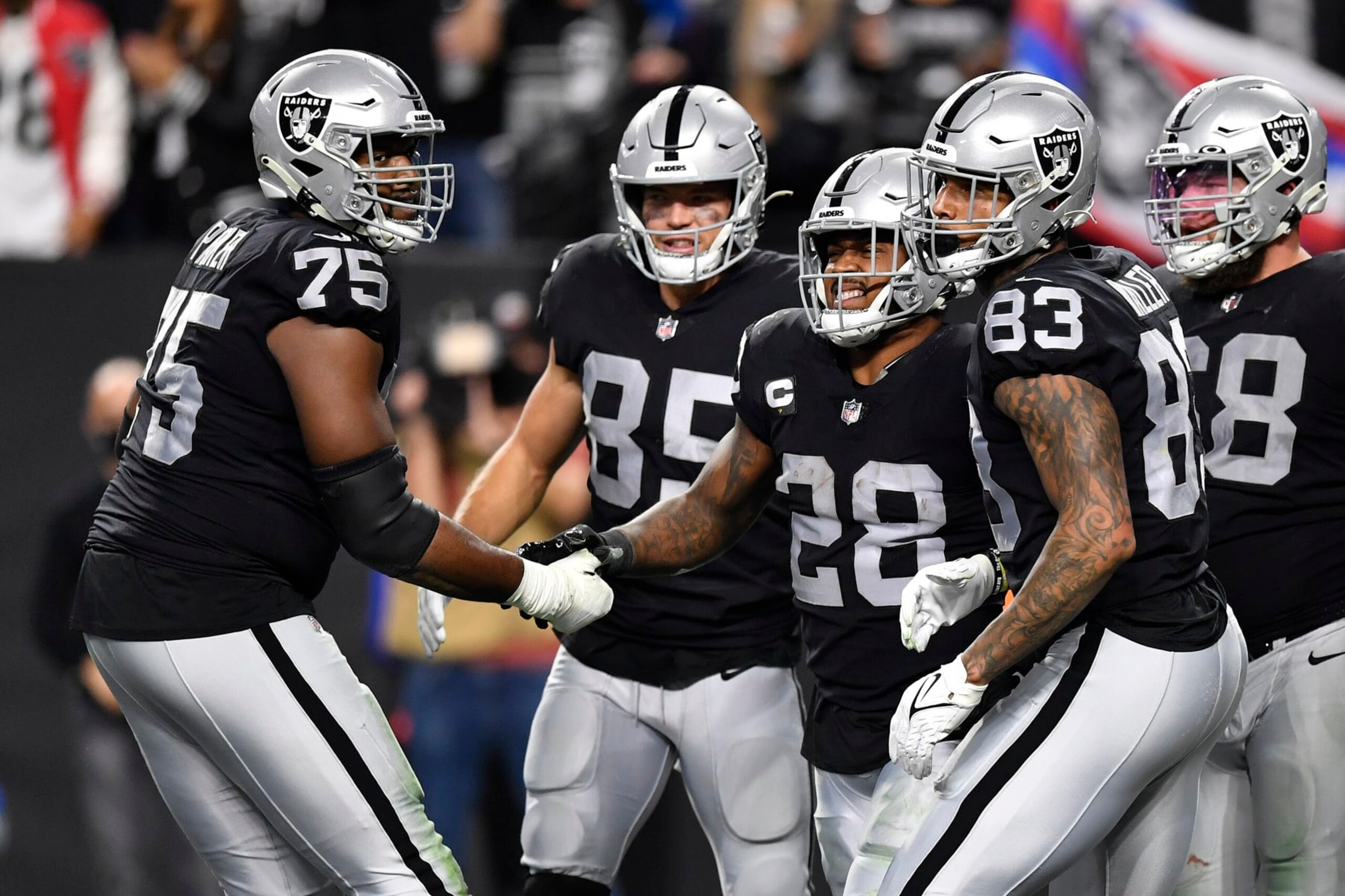 LAS VEGAS, NEVADA - JANUARY 09: Brandon Parker #75 and Josh Jacobs #28 of the Las Vegas Raiders celebrate a touchdown by Jacobs during the second quarter against the Los Angeles Chargers at Allegiant Stadium on January 09, 2022 in Las Vegas, Nevada. (Photo by Chris Unger/Getty Images)