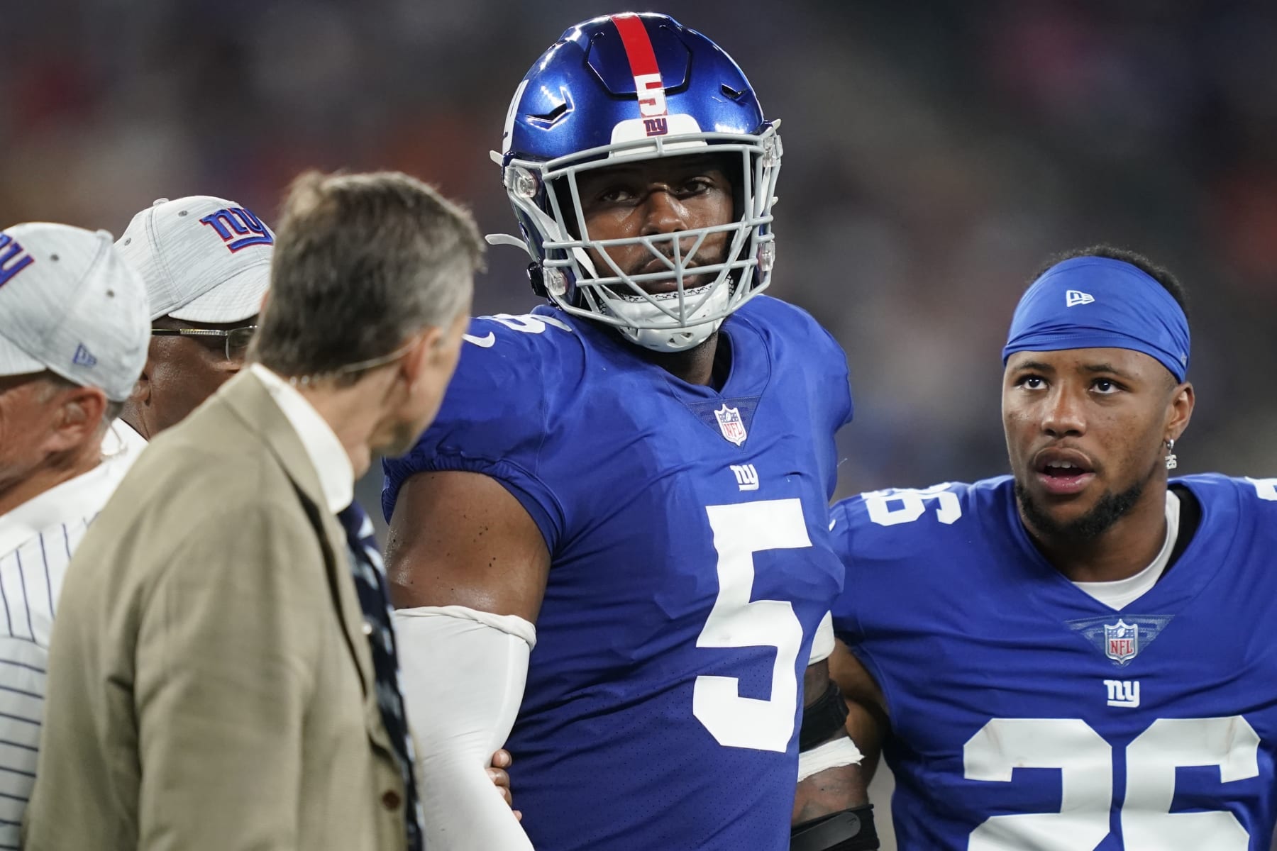 New York Giants' Saquon Barkley (26) checks on Kayvon Thibodeaux (5) as he is helped off the field after getting hurt during the first half of a preseason NFL football game against the Cincinnati Bengals Sunday, Aug. 21, 2022, in East Rutherford, N.J. (AP Photo/John Minchillo)