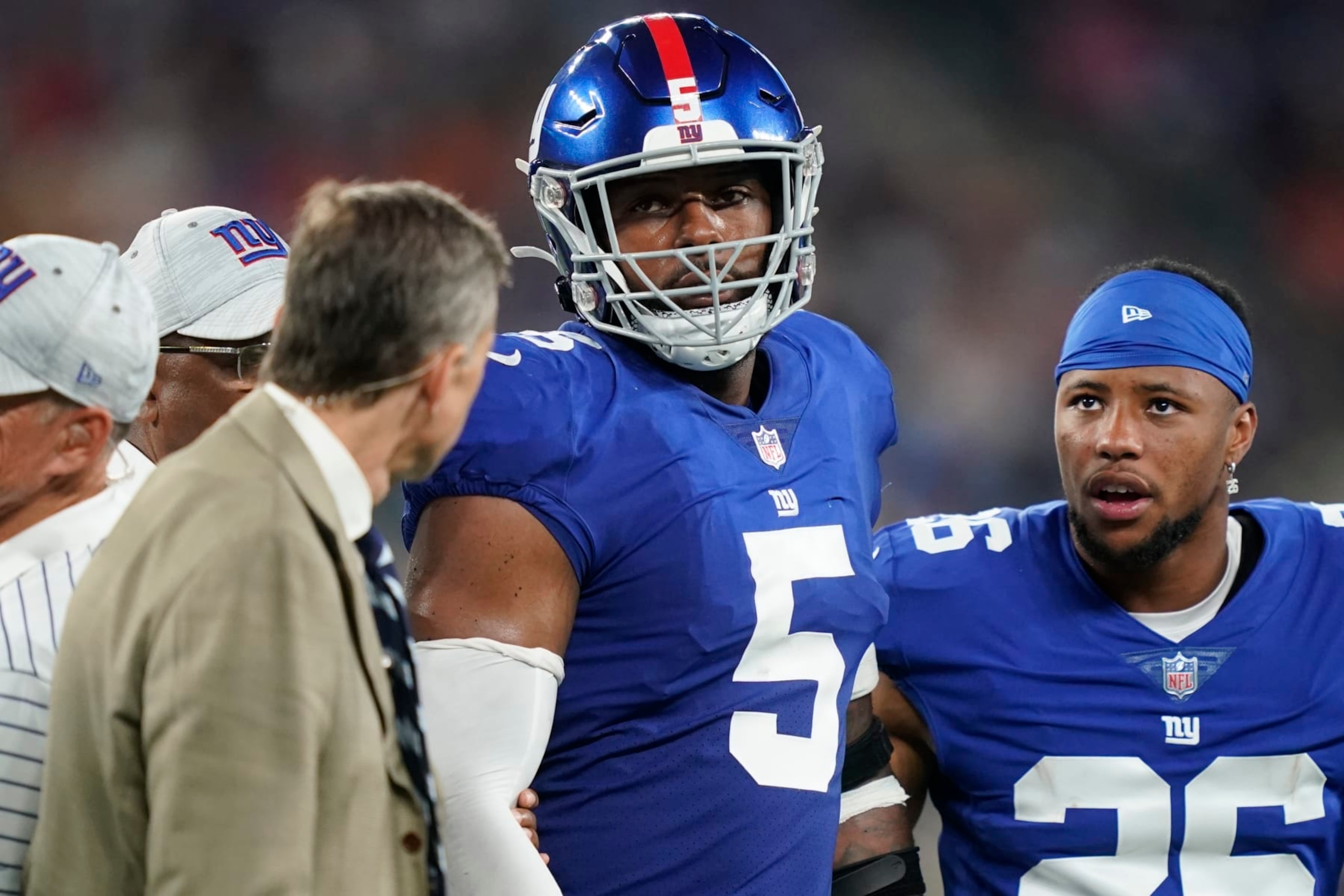 New York Giants' Saquon Barkley (26) checks on Kayvon Thibodeaux (5) as he is helped off the field after getting hurt during the first half of a preseason NFL football game against the Cincinnati Bengals Sunday, Aug. 21, 2022, in East Rutherford, N.J. (AP Photo/John Minchillo)