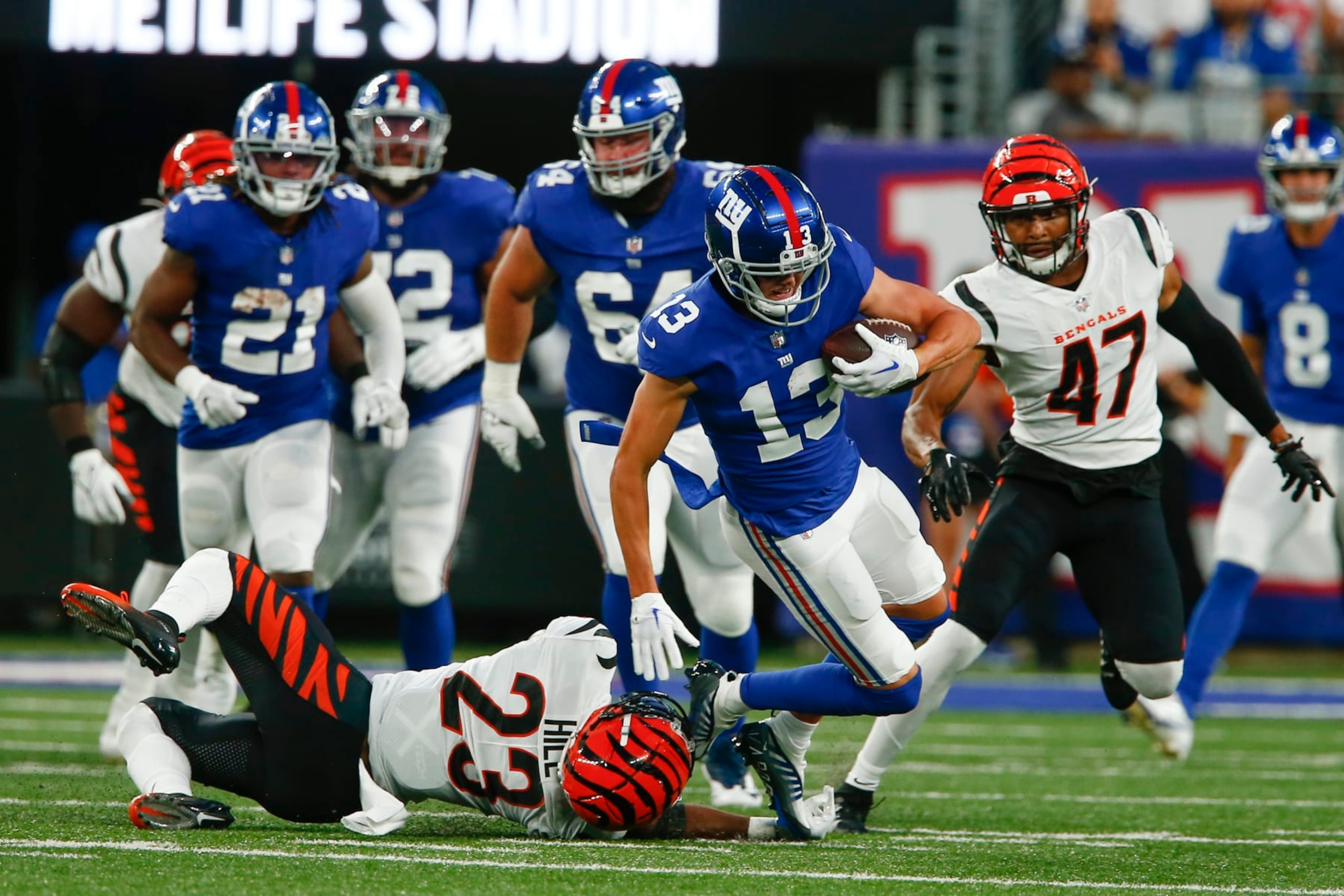 Cincinnati Bengals' Dax Hill (23) tackles New York Giants' David Sills (13) during the first half of a preseason NFL football game, Sunday, Aug. 21, 2022, in East Rutherford, N.J. (AP Photo/John Munson)