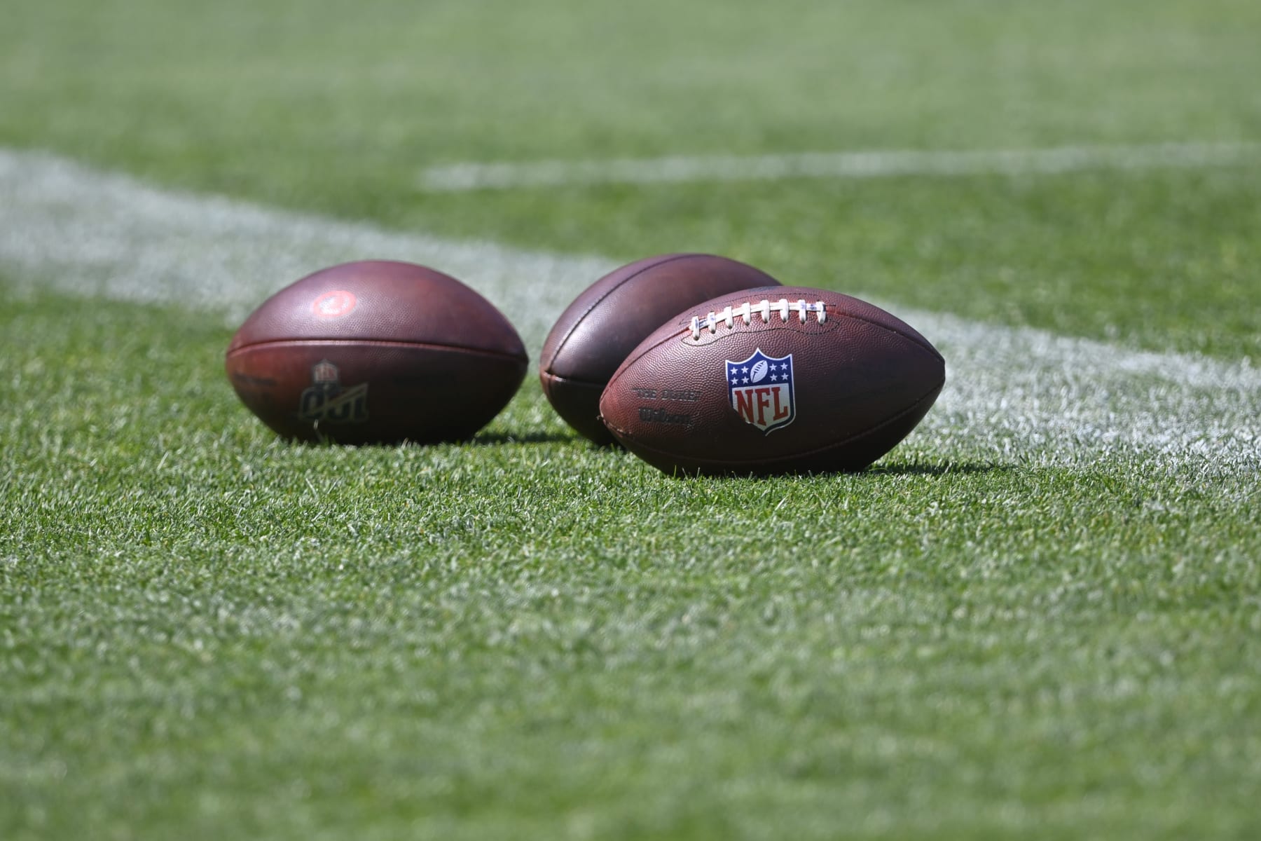 Footballs sit on the field during an NFL football practice at the team's training facility Wednesday, June 1, 2022, in Berea, Ohio. (AP Photo/David Richard)