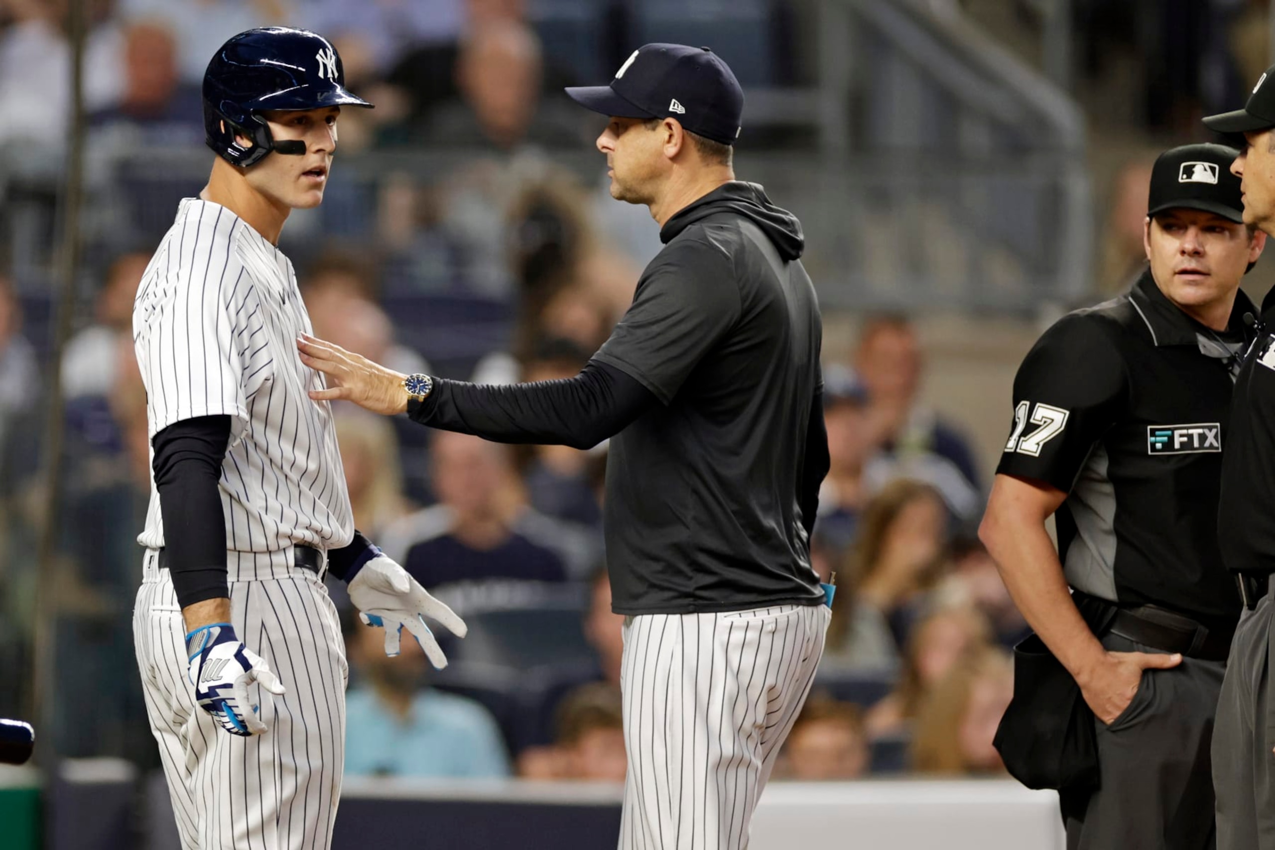 New York Yankees manager Aaron Boone separates Anthony Rizzo, left, from home plate umpire DJ Reyburn (17) during the third inning of the team's baseball game against the Tampa Bay Rays on Monday, Aug. 15, 2022, in New York. (AP Photo/Adam Hunger)