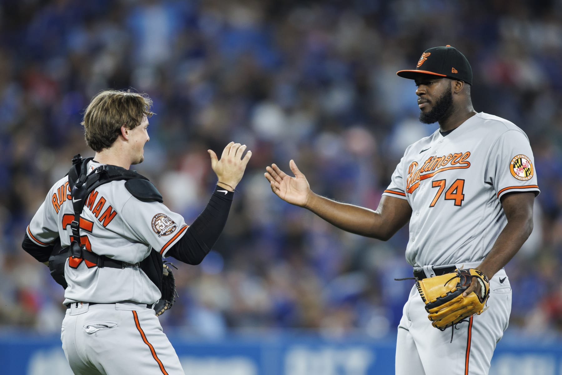 TORONTO, ON - AUGUST 16: Adley Rutschman #35 and Felix Bautista #74 of the Baltimore Orioles celebrate after the final out of their MLB game victory against the Toronto Blue Jays at Rogers Centre on August 16, 2022 in Toronto, Canada. (Photo by Cole Burston/Getty Images)