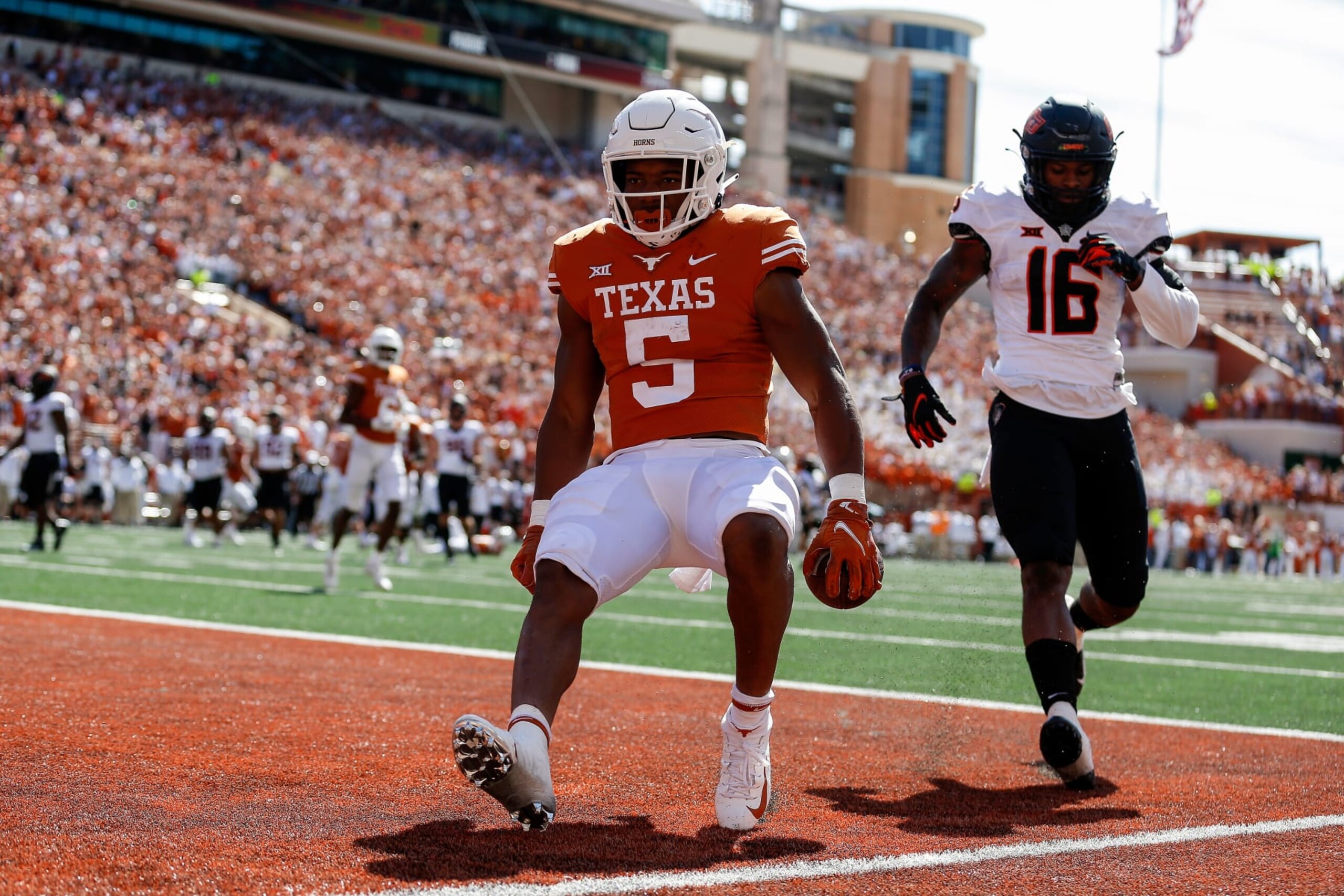 AUSTIN, TEXAS - OCTOBER 16: Bijan Robinson #5 of the Texas Longhorns catches a pass for a touchdown while defended by Devin Harper #16 of the Oklahoma State Cowboys in the second quarter at Darrell K Royal-Texas Memorial Stadium on October 16, 2021 in Austin, Texas. (Photo by Tim Warner/Getty Images) AUSTIN, TEXAS - OCTOBER 16: Bijan Robinson #5 of the Texas Longhorns catches a pass for a touchdown while defended by Devin Harper #16 of the Oklahoma State Cowboys in the second quarter at Darrell K Royal-Texas Memorial Stadium on October 16, 2021 in Austin, Texas. (Photo by Tim Warner/Getty Images)