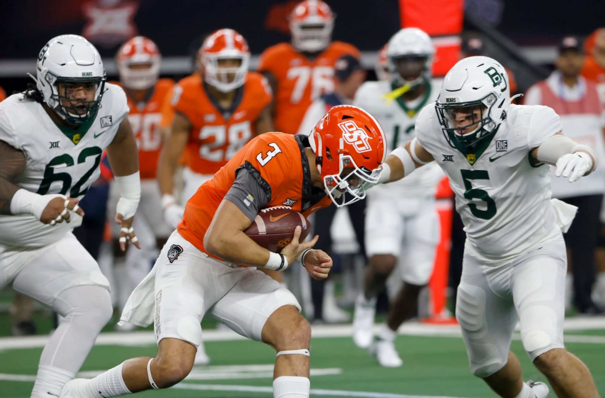 ARLINGTON, TX - DECEMBER 4: Spencer Sanders #3 of the Oklahoma State Cowboys is met by Dillon Doyle #5 and Siaki Ika #62 of the Baylor Bears in the first half of the Big 12 Football Championship at AT&T Stadium on December 4, 2021 in Arlington, Texas. (Photo by Ron Jenkins/Getty Images) ARLINGTON, TX - DECEMBER 4: Spencer Sanders #3 of the Oklahoma State Cowboys is met by Dillon Doyle #5 and Siaki Ika #62 of the Baylor Bears in the first half of the Big 12 Football Championship at AT&T Stadium on December 4, 2021 in Arlington, Texas. (Photo by Ron Jenkins/Getty Images)