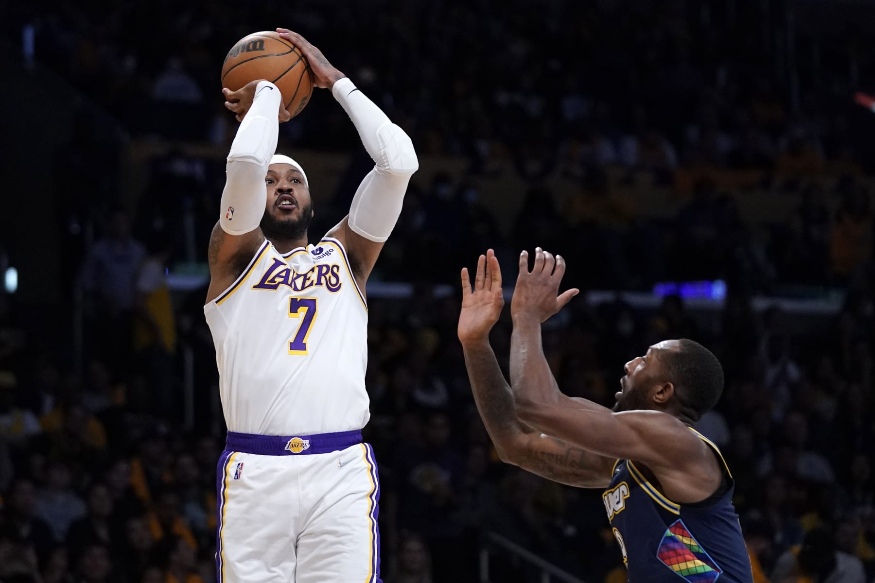 Los Angeles Lakers forward Carmelo Anthony, left, shoots as Denver Nuggets guard Davon Reed defends during the first half of an NBA basketball game Sunday, April 3, 2022, in Los Angeles. (AP Photo/Mark J. Terrill)