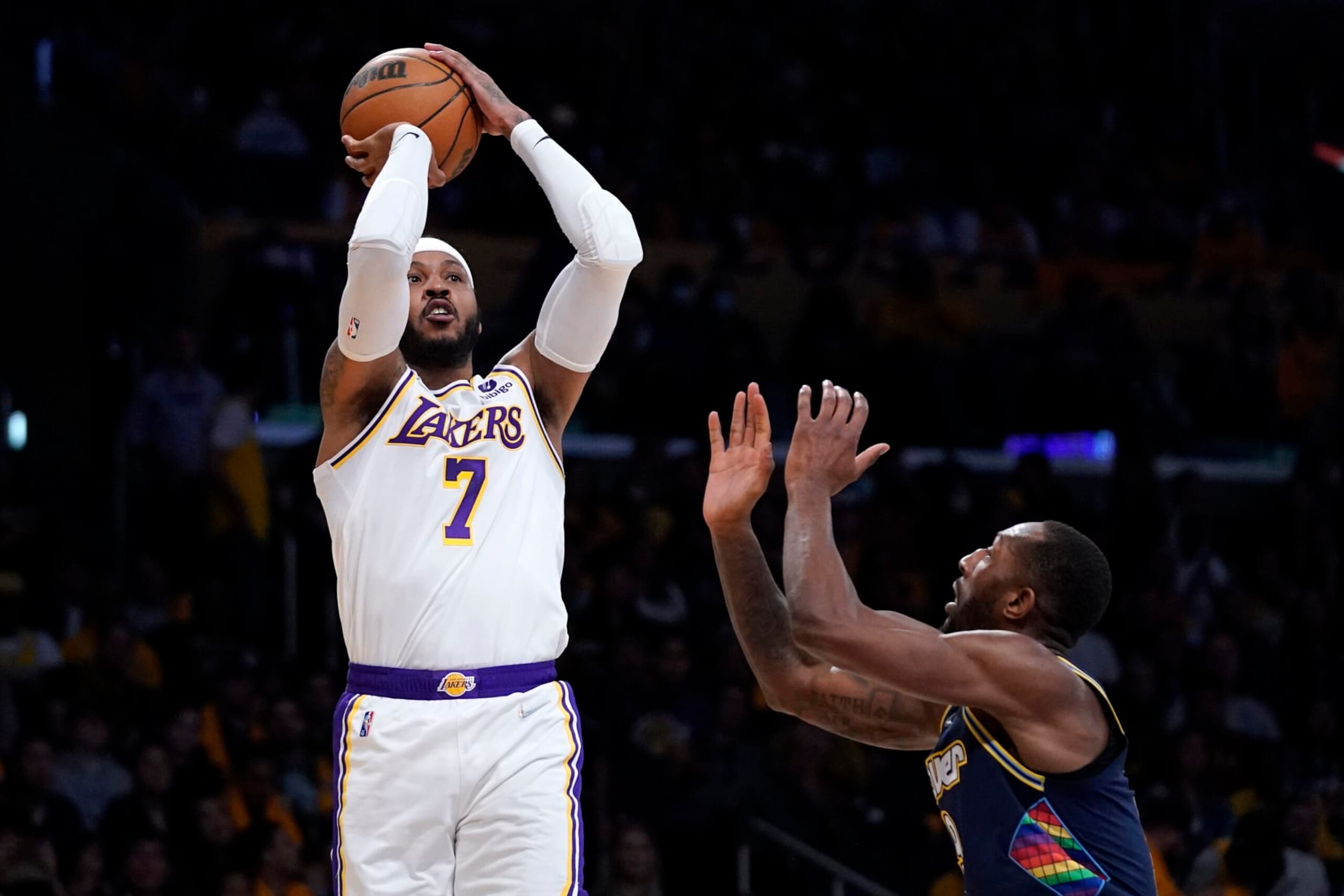 Los Angeles Lakers forward Carmelo Anthony, left, shoots as Denver Nuggets guard Davon Reed defends during the first half of an NBA basketball game Sunday, April 3, 2022, in Los Angeles. (AP Photo/Mark J. Terrill)