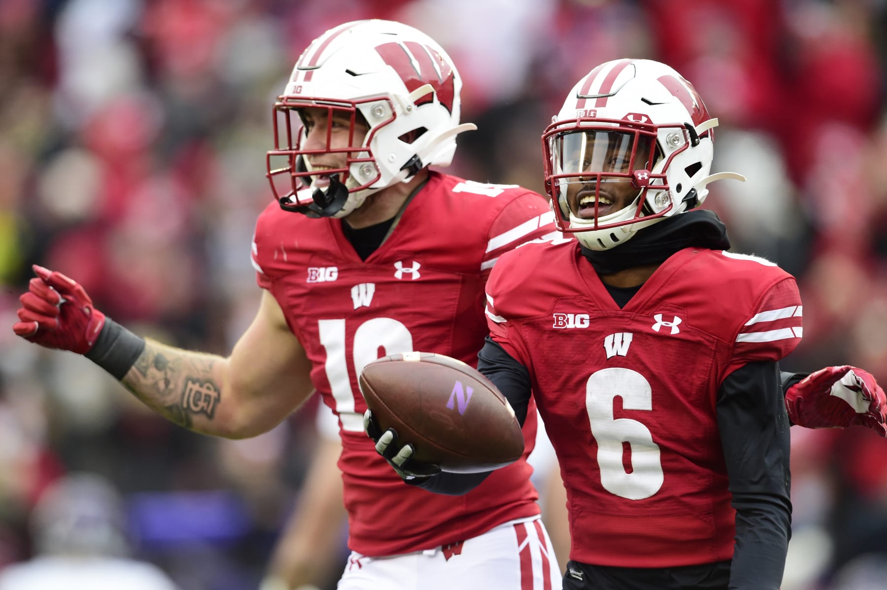 MADISON, WISCONSIN - NOVEMBER 13: Dean Engram #6 of the Wisconsin Badgers celebrates with teammate Nick Herbig #19 after intercepting a pass against the Northwestern Wildcats in the second half at Camp Randall Stadium on November 13, 2021 in Madison, Wisconsin. (Photo by Patrick McDermott/Getty Images)