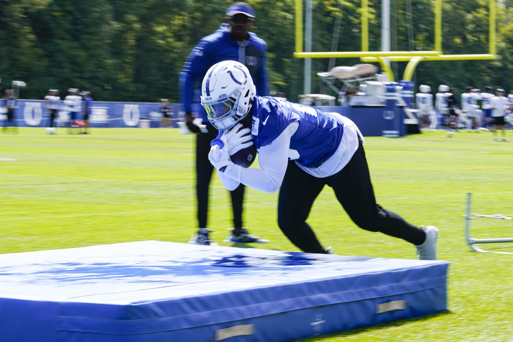 Indianapolis Colts running back Jonathan Taylor (28) dives on to a pad during practice at the NFL team's football training camp in Westfield, Ind., Wednesday, Aug. 24, 2022. (AP Photo/Michael Conroy)
