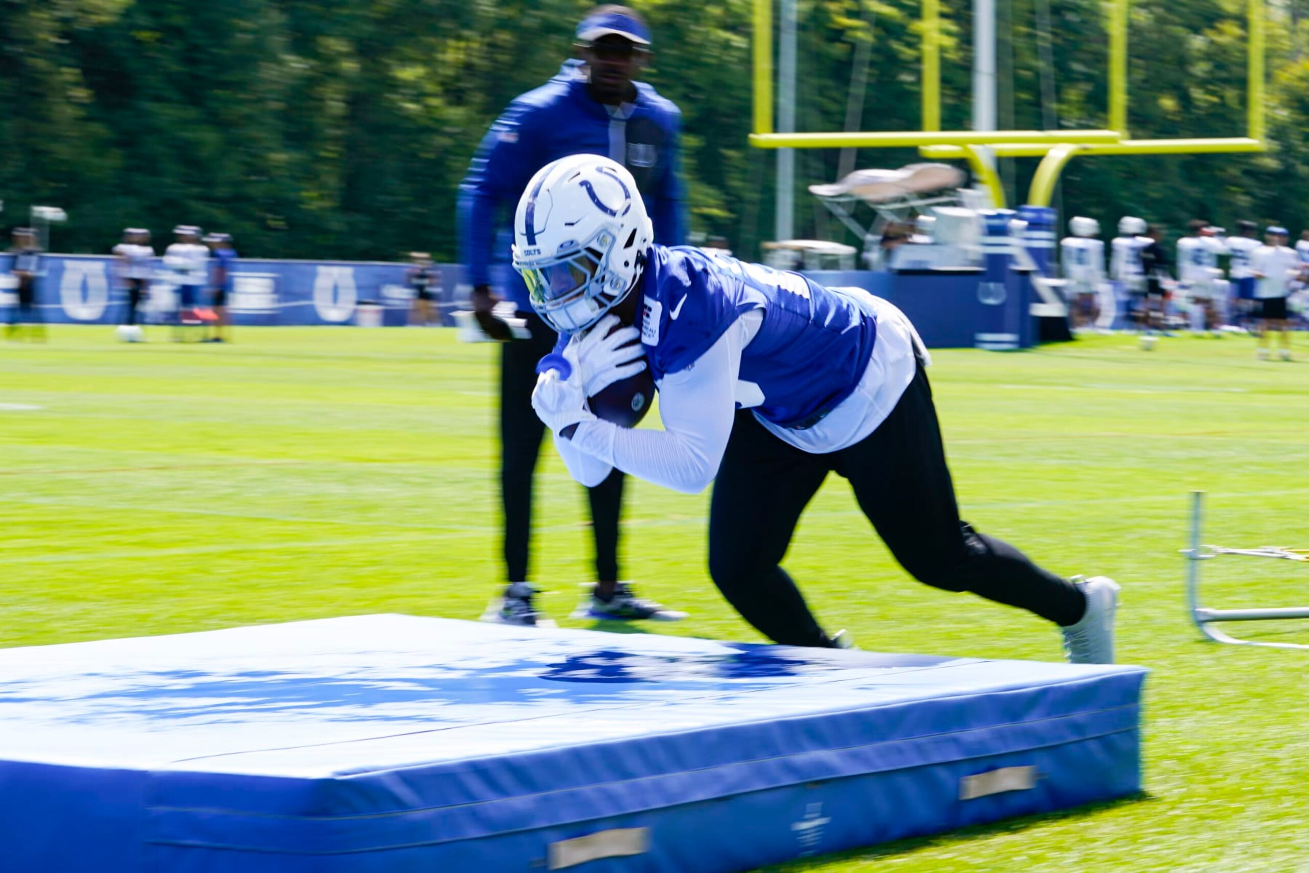 Indianapolis Colts running back Jonathan Taylor (28) dives on to a pad during practice at the NFL team's football training camp in Westfield, Ind., Wednesday, Aug. 24, 2022. (AP Photo/Michael Conroy)