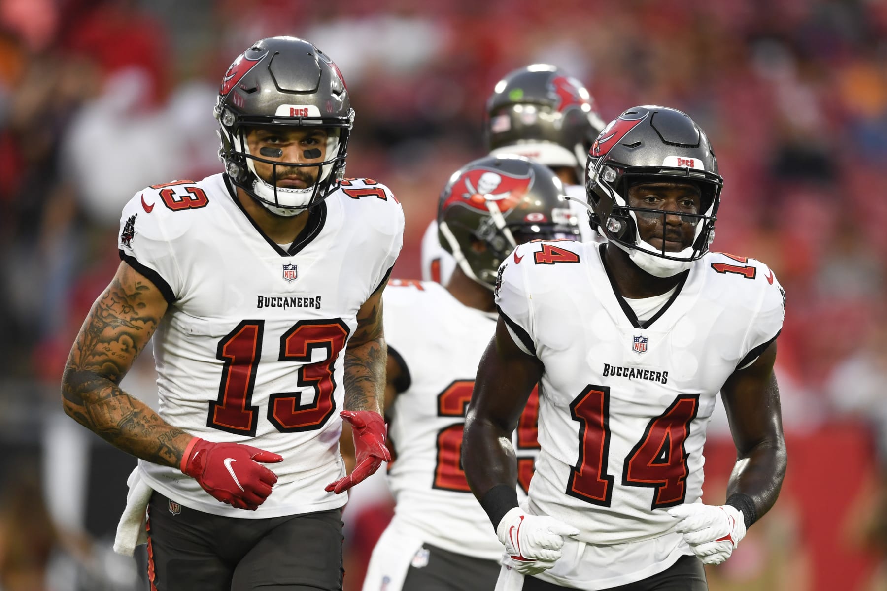 TAMPA, FLORIDA - AUGUST 14: Mike Evans #13 and Chris Godwin #14 of the Tampa Bay Buccaneers break from the huddle during the first quarter against the Cincinnati Bengals during a preseason game at Raymond James Stadium on August 14, 2021 in Tampa, Florida. (Photo by Douglas P. DeFelice/Getty Images)
