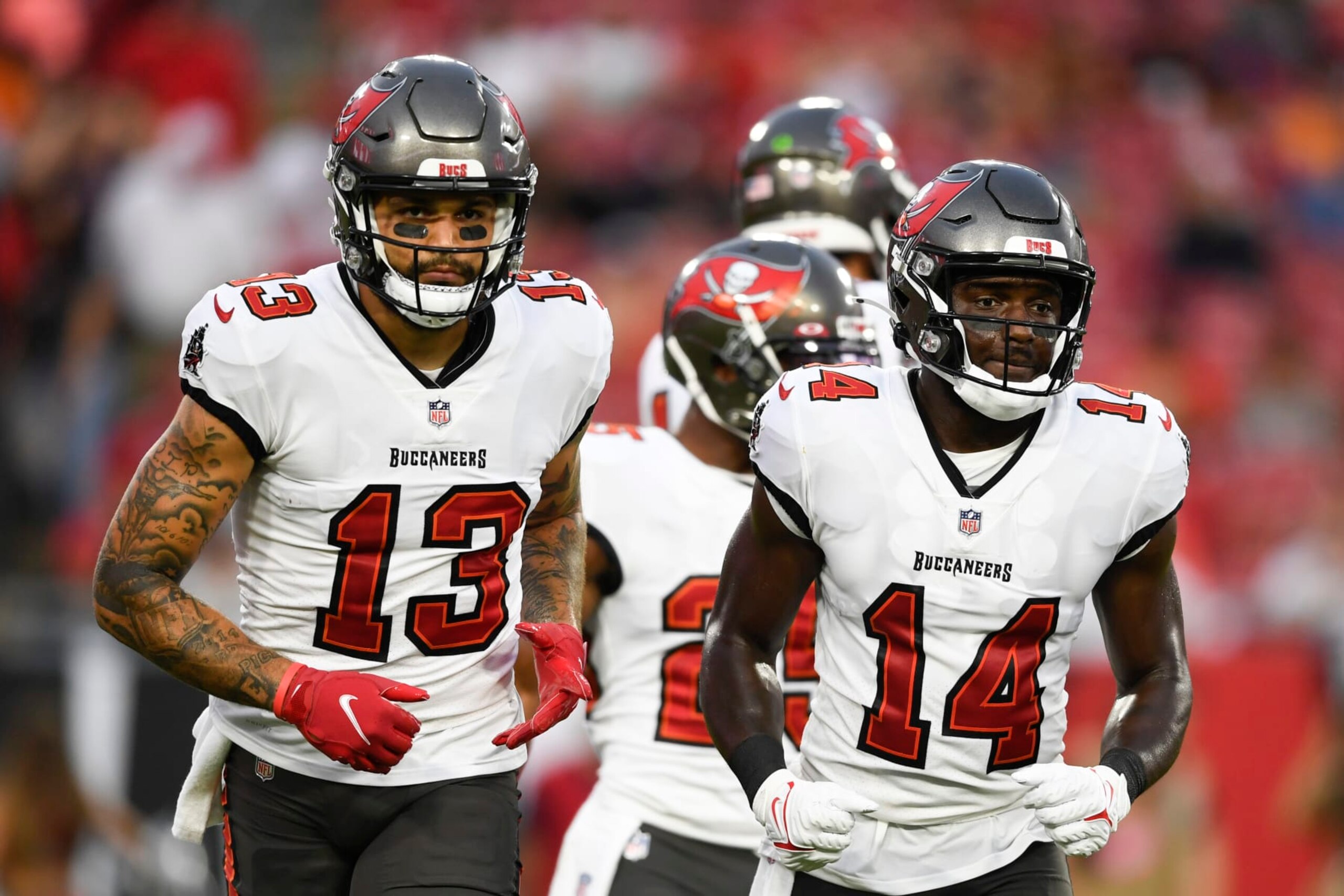 TAMPA, FLORIDA - AUGUST 14: Mike Evans #13 and Chris Godwin #14 of the Tampa Bay Buccaneers break from the huddle during the first quarter against the Cincinnati Bengals during a preseason game at Raymond James Stadium on August 14, 2021 in Tampa, Florida. (Photo by Douglas P. DeFelice/Getty Images)