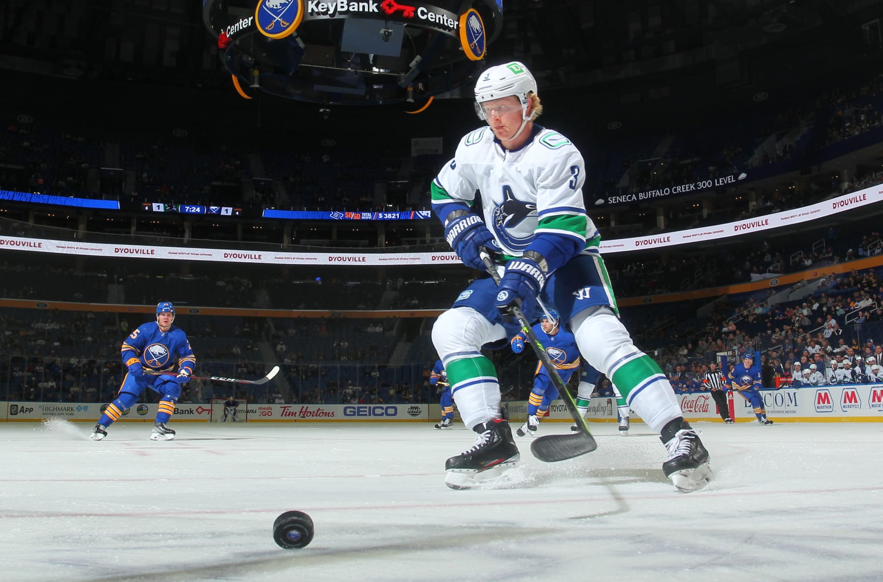 BUFFALO, NY - OCTOBER 19: Jack Rathbone #3 of the Vancouver Canucks looks to control the puck against the Buffalo Sabres during an NHL game on October 19, 2021 at KeyBank Center in Buffalo, New York. (Photo by Bill Wippert/NHLI via Getty Images)