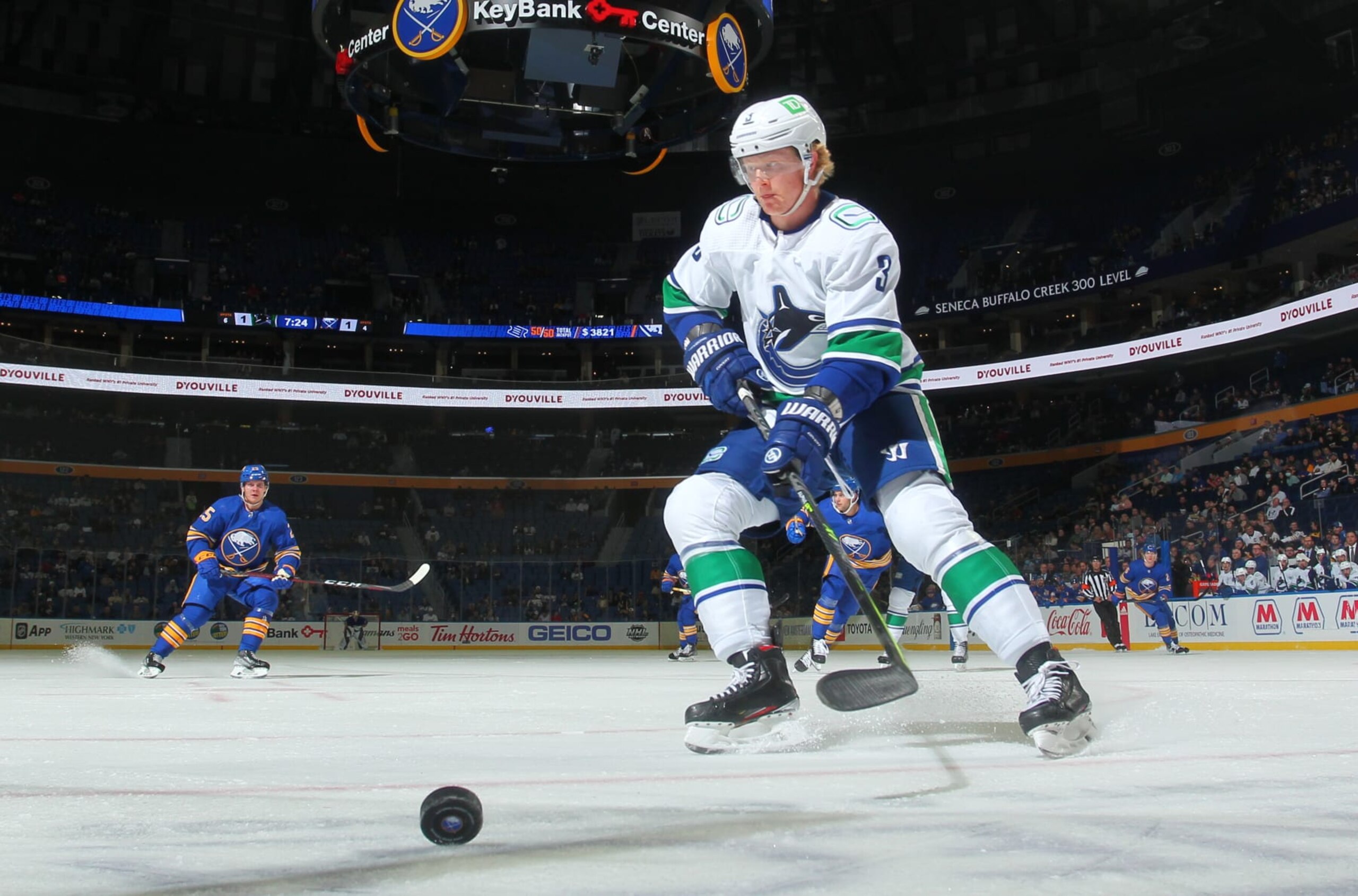 BUFFALO, NY - OCTOBER 19: Jack Rathbone #3 of the Vancouver Canucks looks to control the puck against the Buffalo Sabres during an NHL game on October 19, 2021 at KeyBank Center in Buffalo, New York. (Photo by Bill Wippert/NHLI via Getty Images)