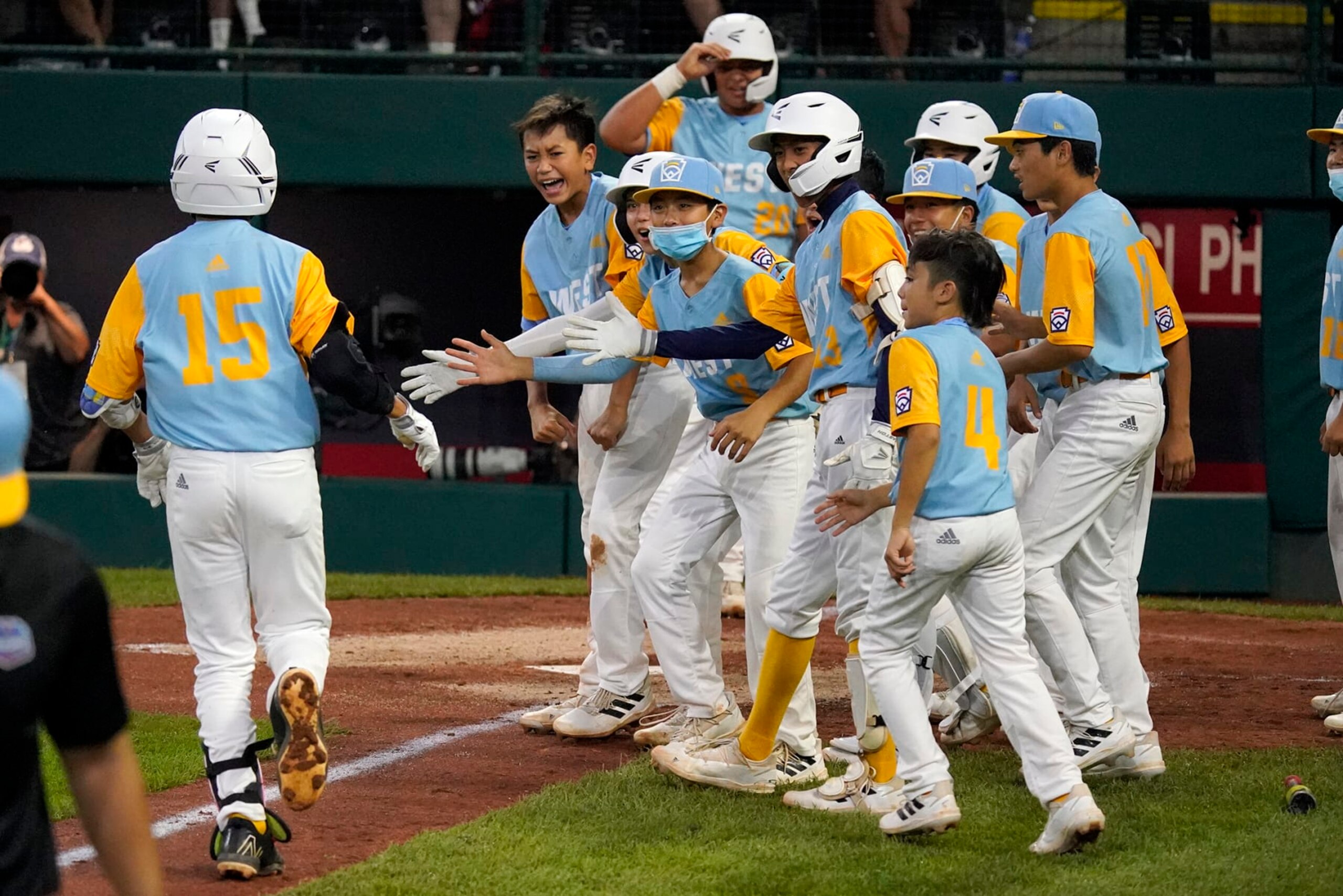 Honolulu, Hawaii's Keko Payanal (15) is greeted by teammates after hitting a two-run home run off Massapequa, N.Y.'s Danny Fregara during the fourth inning of a baseball game at the Little League World Series in South Williamsport, Pa., Friday, Aug. 19, 2022. (AP Photo/Gene J. Puskar)