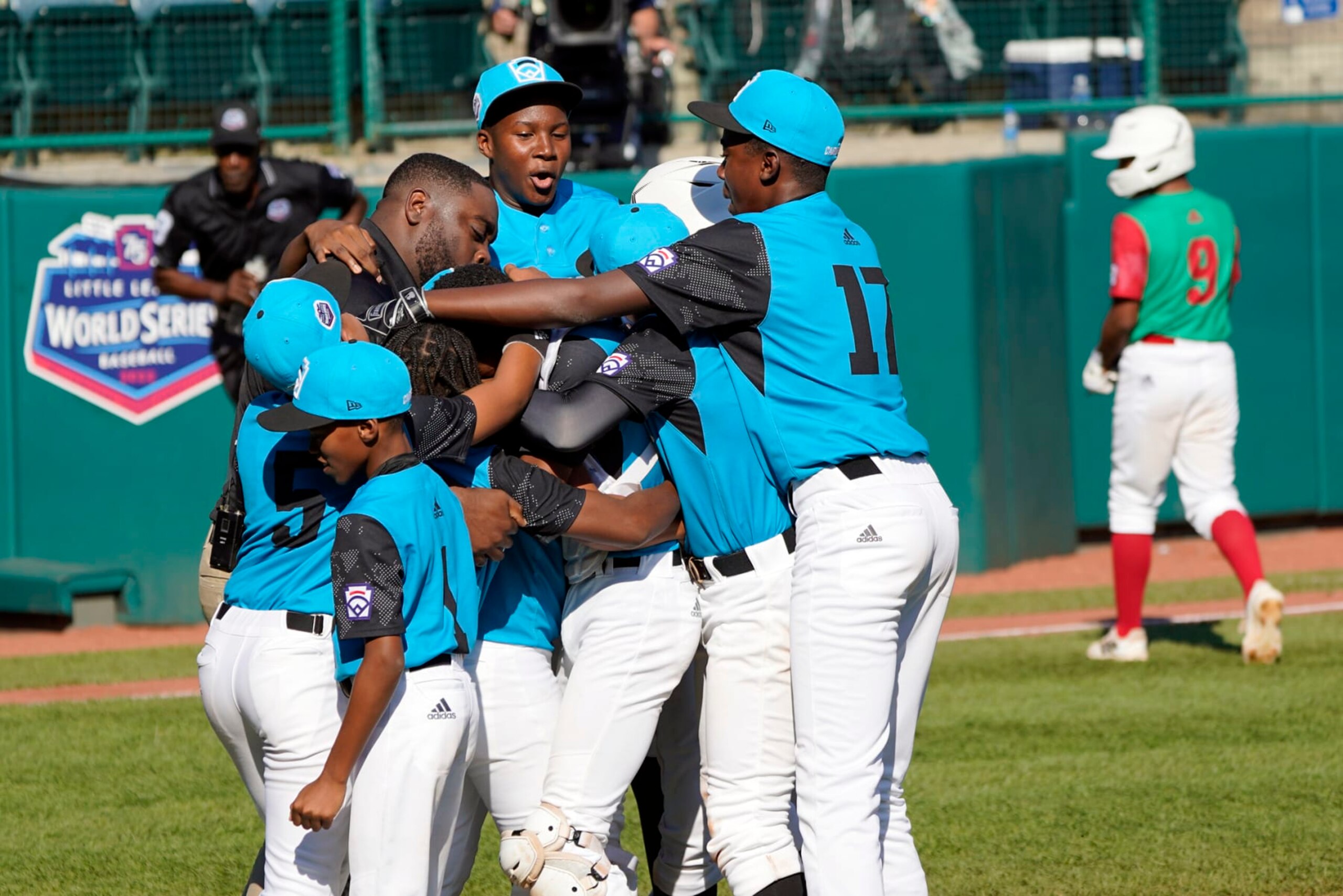 Curacao celebrates after the final out of the game as Mexico's Miguel Padila (9) walks off the field during a baseball game at the Little League World Series tournament in South Williamsport, Pa., Thursday, Aug. 25, 2022. (AP Photo/Tom E. Puskar)