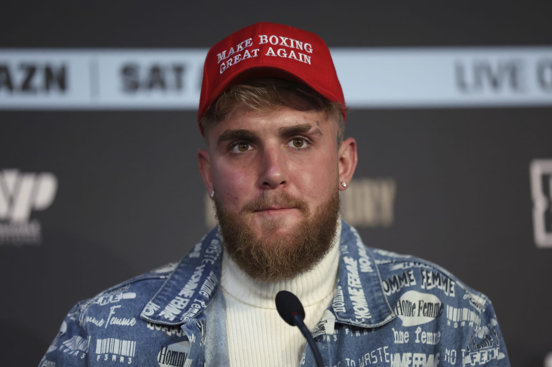 Boxing co-promoter Jake Paul wears a "Make Boxing Great Again" cap during a press conference at the Leadenhall Building in London, on the second leg of the press tour to promote the upcoming fight between Ireland's Katie Taylor and Puerto Rico's Amanda Serrano, Monday, Feb. 7, 2022. In one of the biggest events in women's boxing history Katie Taylor will defend her lightweight titles against Amanda Serrano on April 30 in what organizers say will be the first women's boxing match to headline Madison Square Garden. (AP Photo/Ian Walton)
