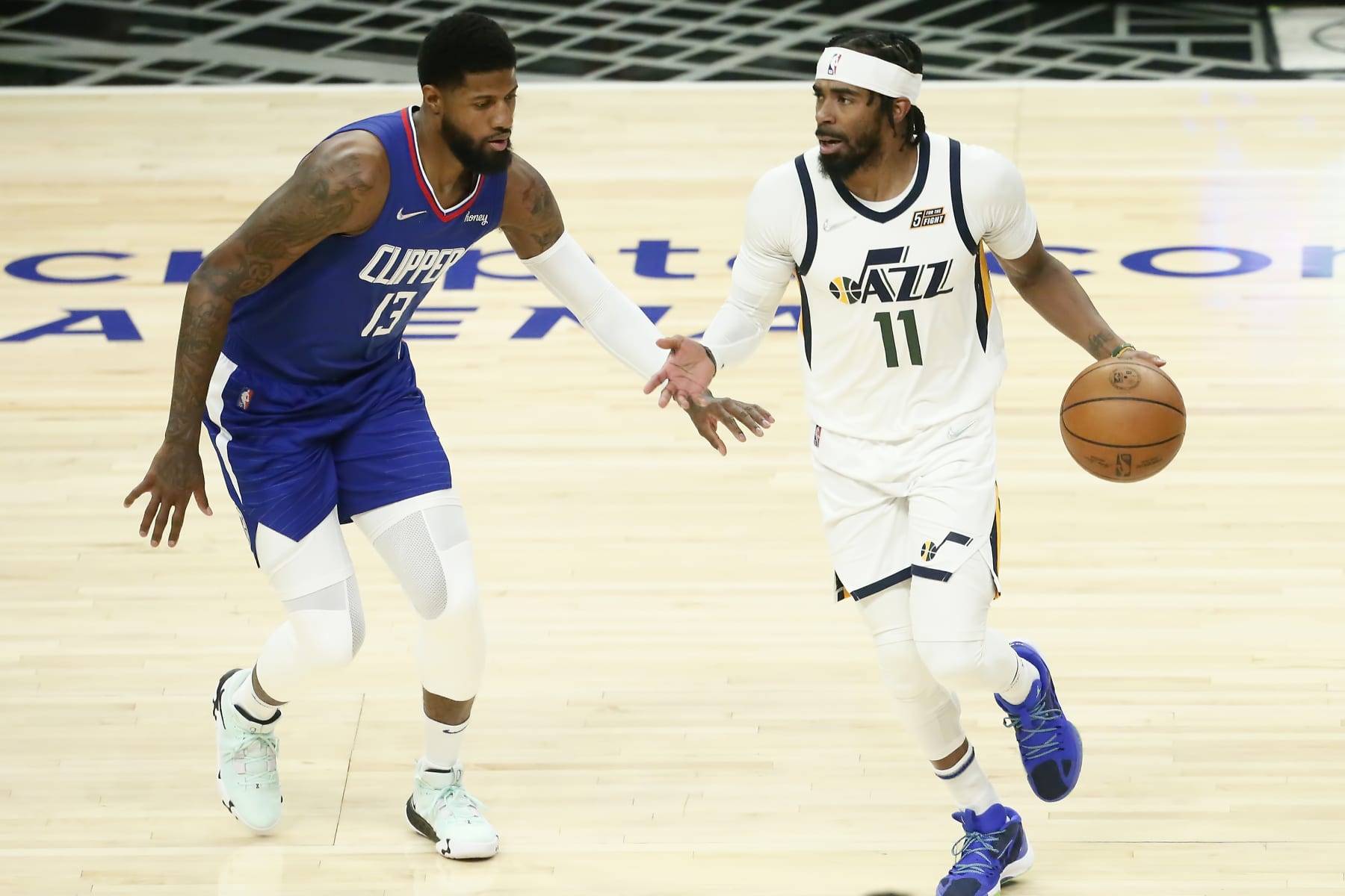 LOS ANGELES, CA - MARCH 29: Paul George #13 of the LA Clippers defends on Mike Conley #11 of the Utah Jazz during a game at the Crypto.com Arena on March 29, 2022 in Los Angeles, California. NOTE TO USER: User expressly acknowledges and agrees that, by downloading and or using this photograph, User is consenting to the terms and conditions of the Getty Images License Agreement. Mandatory Credit: 2022 NBAE (Photo by Chris Elise/NBAE via Getty Images)