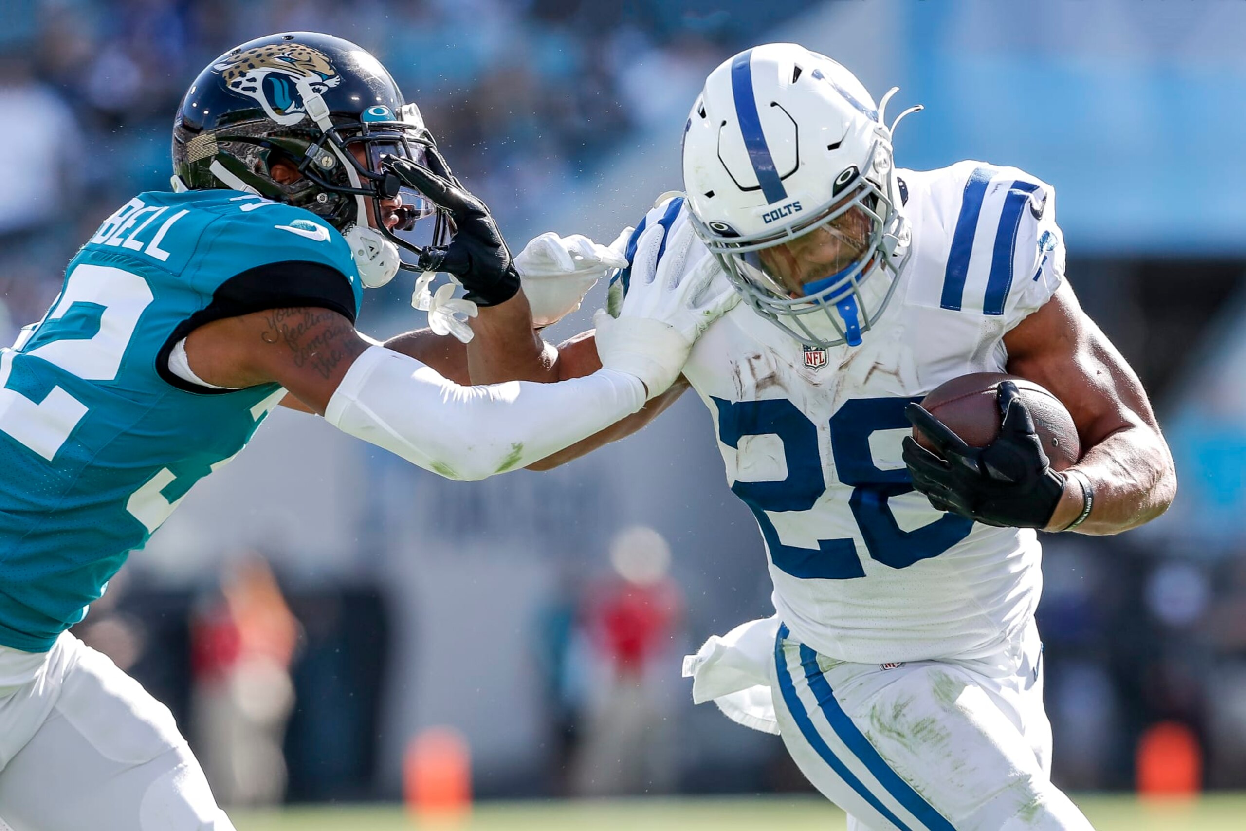 JACKSONVILLE, FL - JANUARY 9:  Running back Jonathan Taylor #28 of the Indianapolis Colts gives a stiff arm to corner back Tyson Campbell #32 of the Jacksonville Jaguars at TIAA Bank Field on January 9, 2022 in Jacksonville, Florida. The Jaguars won 26 -11. (Photo by Don Juan Moore/Getty Images)