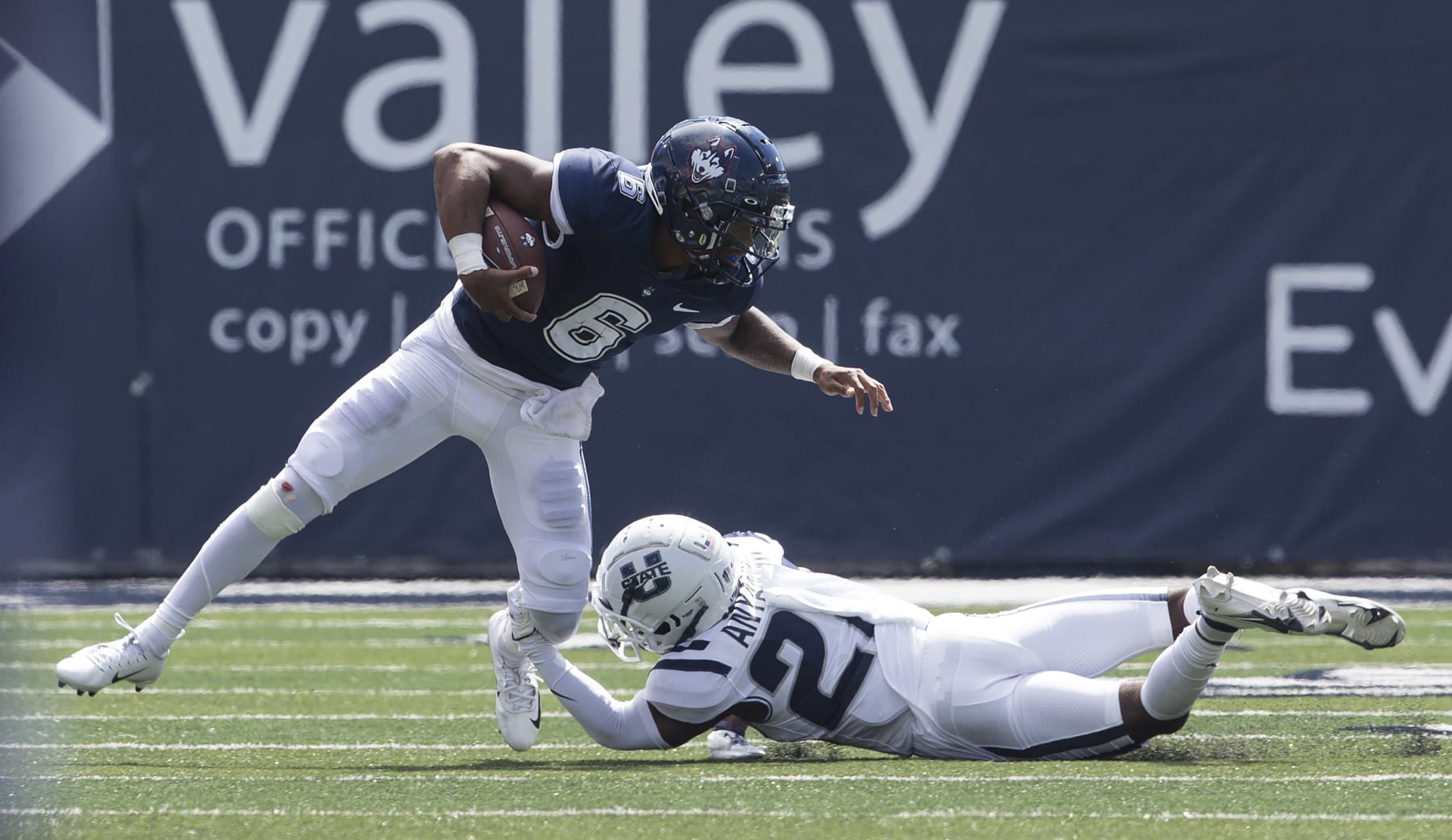 LOGAN, UT- AUGUST 27:  Ta' Quan Roberson #6 of the Connecticut Huskies tries to get away from a tackle by Michael Anyanwu #22 of the Utah State Aggies during the first half of their game on August 27, 2022 at Maverik Stadium in Logan, Utah. (Photo by Chris Gardner/Getty Images)