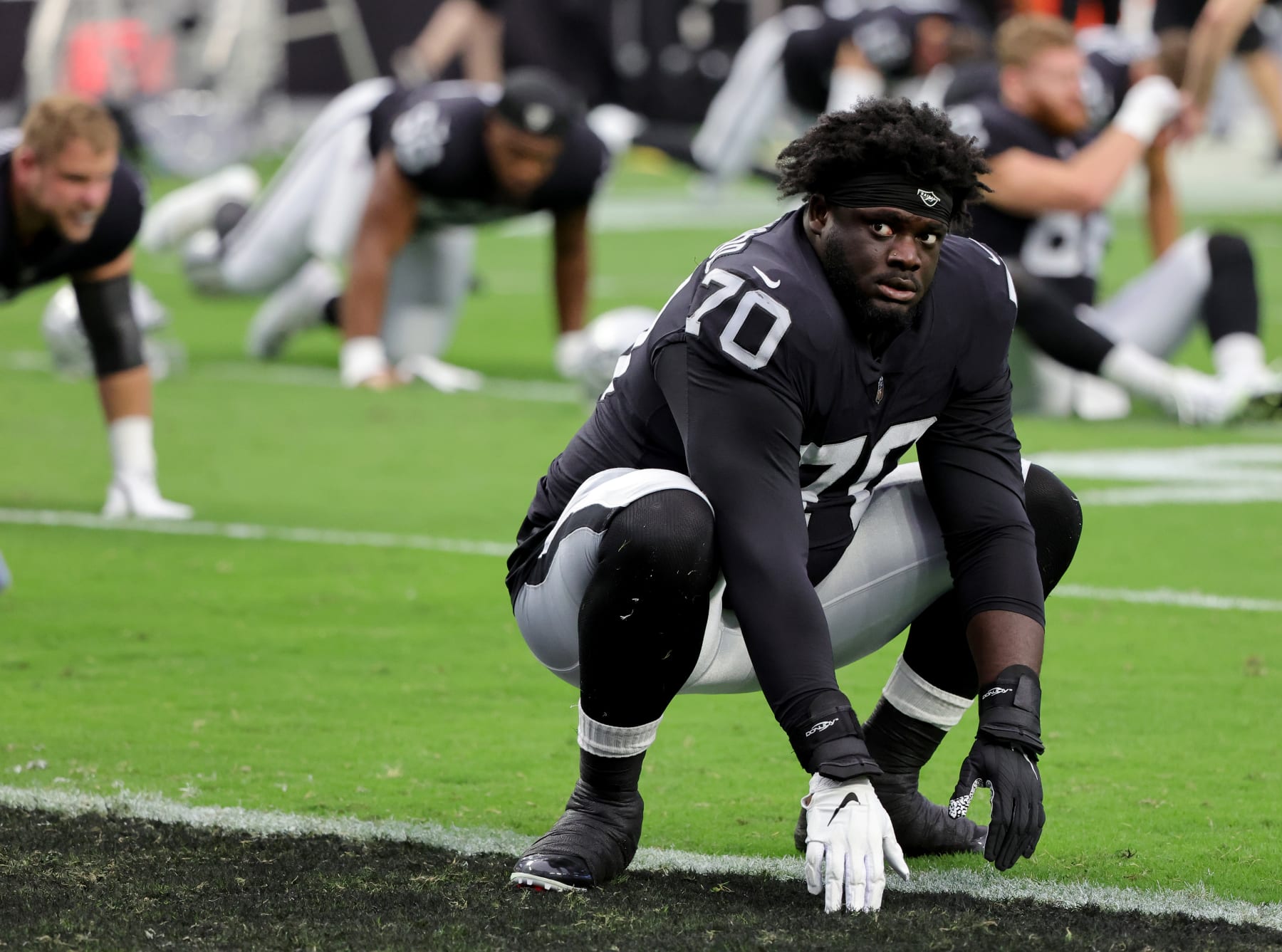 LAS VEGAS, NEVADA - AUGUST 26: Offensive tackle Alex Leatherwood #70 of the Las Vegas Raiders stretches during warmups before a preseason game against the New England Patriots at Allegiant Stadium on August 26, 2022 in Las Vegas, Nevada. The Raiders defeated the Patriots 23-6. (Photo by Ethan Miller/Getty Images)