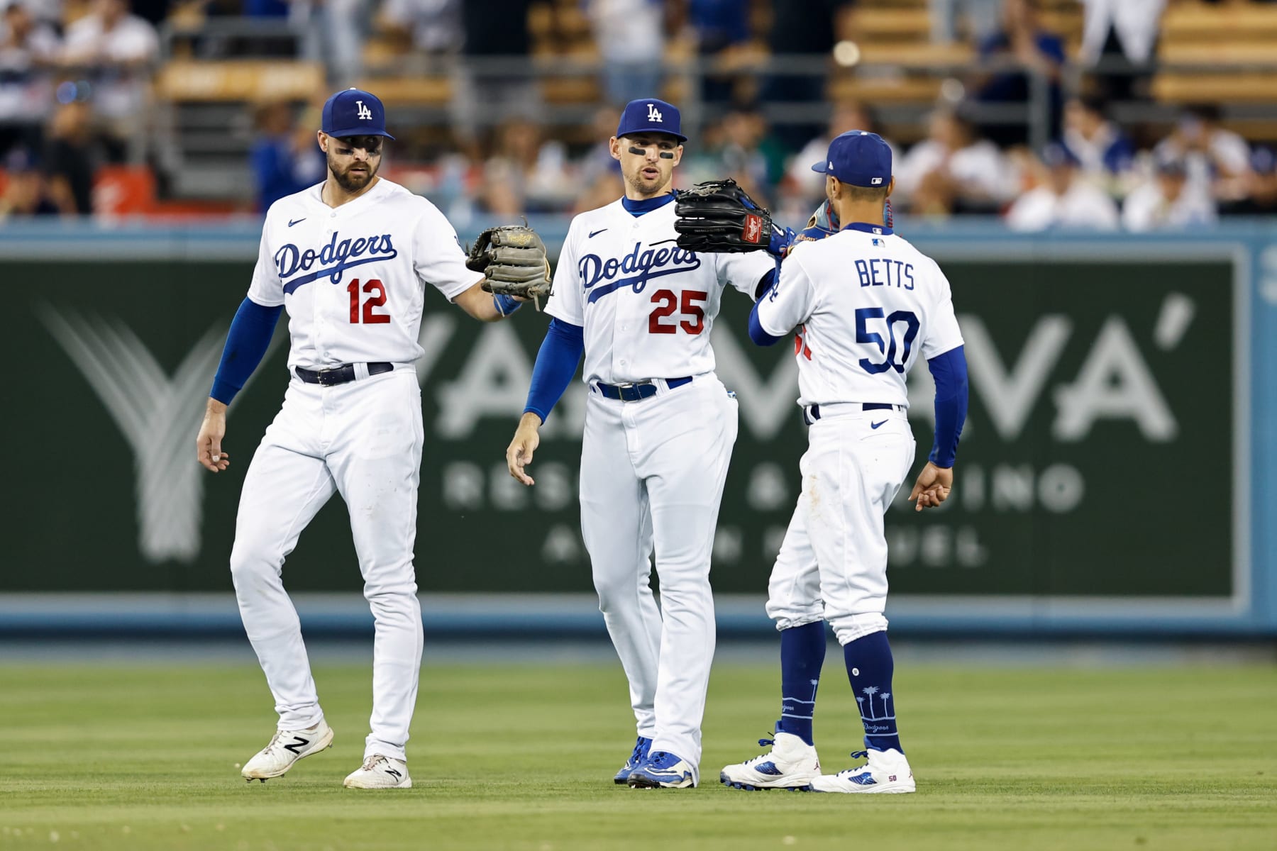 LOS ANGELES, CA - AUGUST 24:   Joey Gallo #12, Trayce Thompson #25 and Mookie Betts #50 of the Los Angeles Dodgers celebrate their win over the Milwaukee Brewers at Dodgers Stadium on Wednesday, August 24, 2022 in Los Angeles, California. (Photo by Michael Owens/MLB Photos via Getty Images)