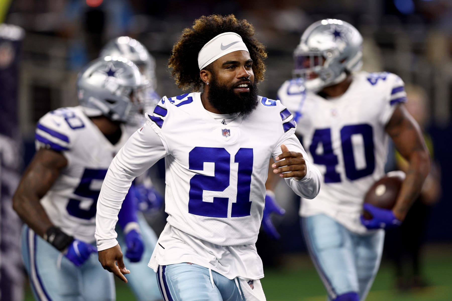 ARLINGTON, TEXAS - AUGUST 26: Running back Ezekiel Elliott #21 of the Dallas Cowboys celebrates after safety Juanyeh Thomas #40 of the Dallas Cowboys intercepted a pass thrown by quarterback Jacob Eason #17 of the Seattle Seahawks in the fourth quarter of a NFL preseason football game at AT&T Stadium on August 26, 2022 in Arlington, Texas. (Photo by Tom Pennington/Getty Images)