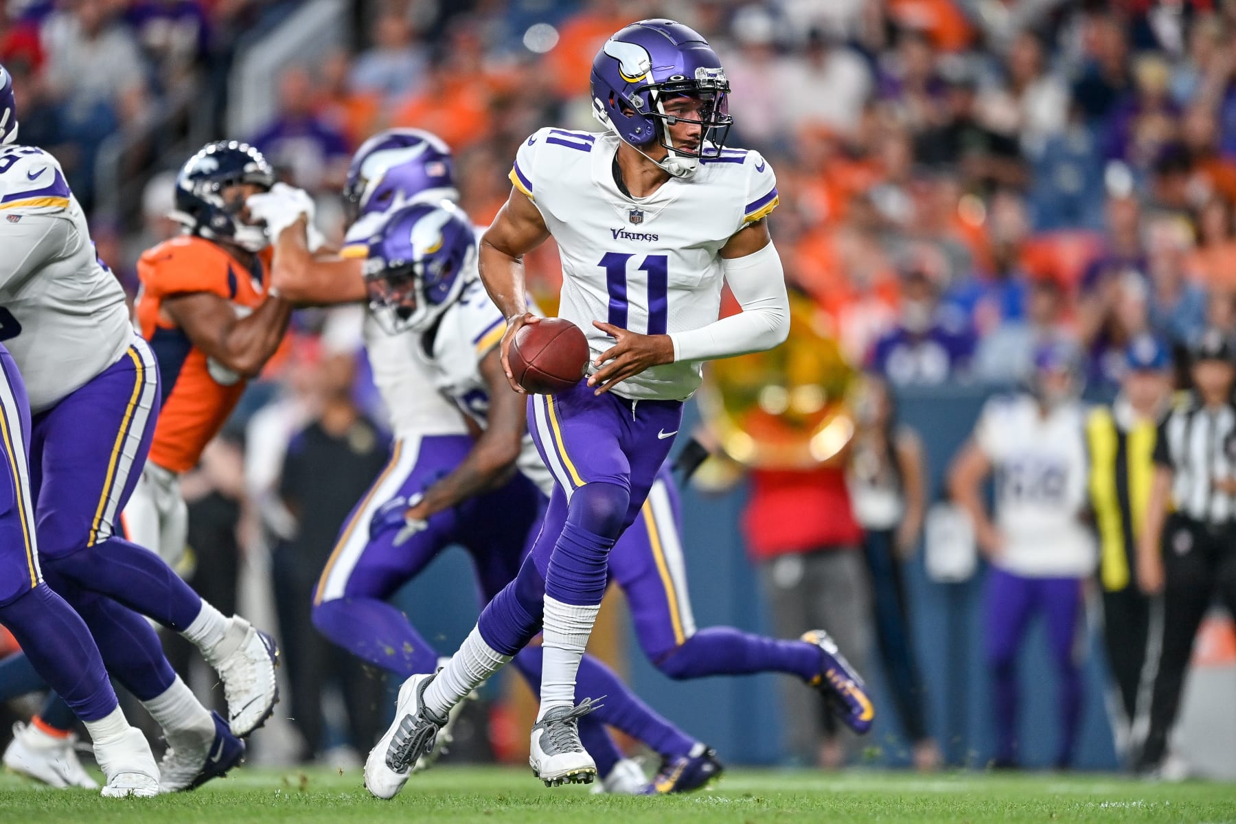 DENVER, COLORADO - AUGUST 27:  Quarterback Kellen Mond #11 of the Minnesota Vikings sets to hand off the ball in a preseason NFL game against the Denver Broncos at Empower Field at Mile High on August 27, 2022 in Denver, Colorado. (Photo by Dustin Bradford/Getty Images)