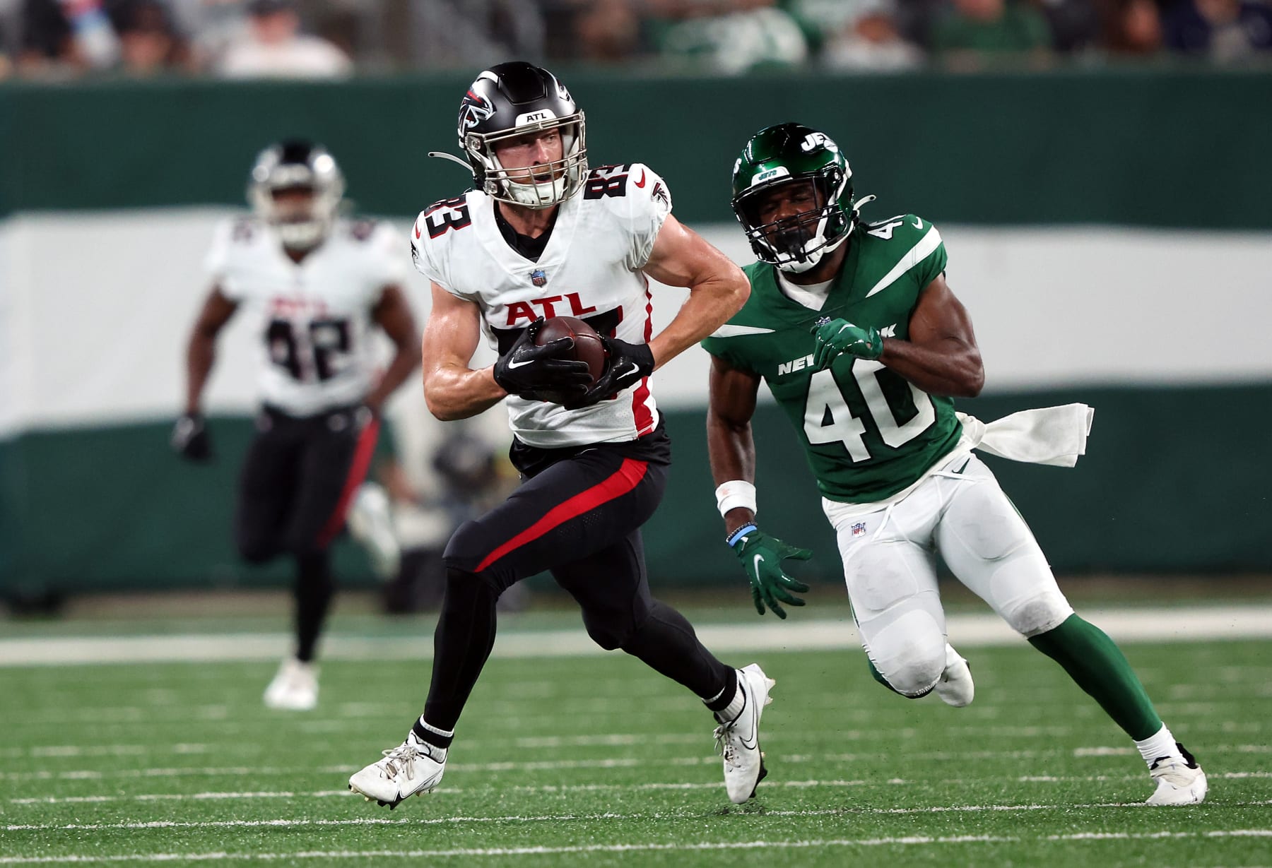 EAST RUTHERFORD, NEW JERSEY - AUGUST 22:  Wide receiver Jared Bernhardt #83 of the Atlanta Falcons carries the ball as cornerback Javelin Guidry #40 of the New York Jets chases during the preseason game at MetLife Stadium on August 22, 2022 in East Rutherford, New Jersey. (Photo by Jamie Squire/Getty Images)