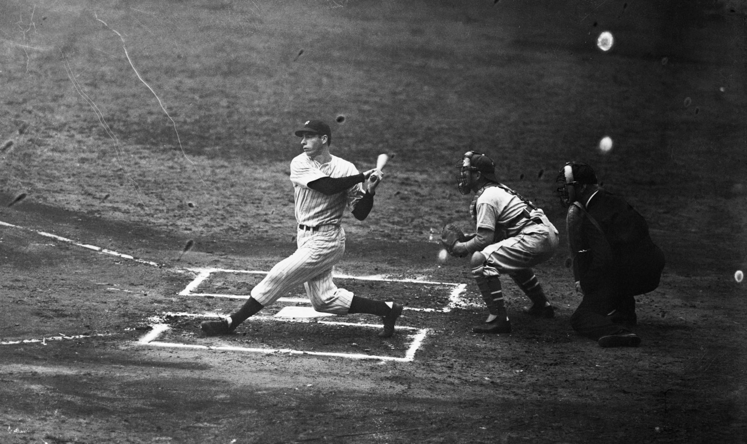 (Original Caption) Joe DiMaggio, star slugger and center fielder of the New York Yankees, shown following through after belting out a single in the first inning of the world series opener against the giants at the Yankee stadium today, October 6. This single advanced Frank Crosetti to second.