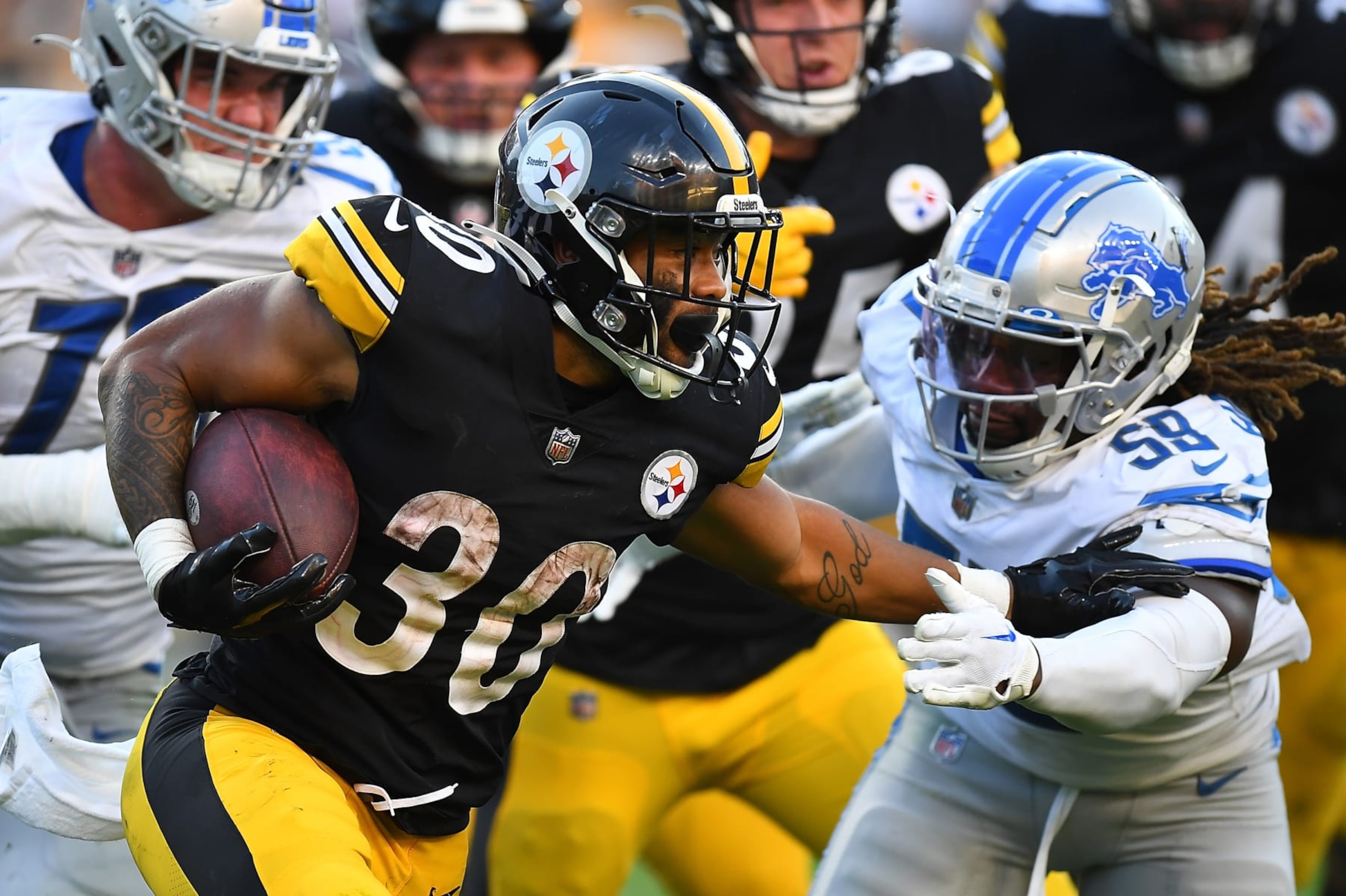 PITTSBURGH, PA - AUGUST 28:  Jaylen Warren #30 of the Pittsburgh Steelers carries the ball in front of James Houston #59 of the Detroit Lions during the fourth quarter at Acrisure Stadium on August 28, 2022 in Pittsburgh, Pennsylvania. (Photo by Joe Sargent/Getty Images)