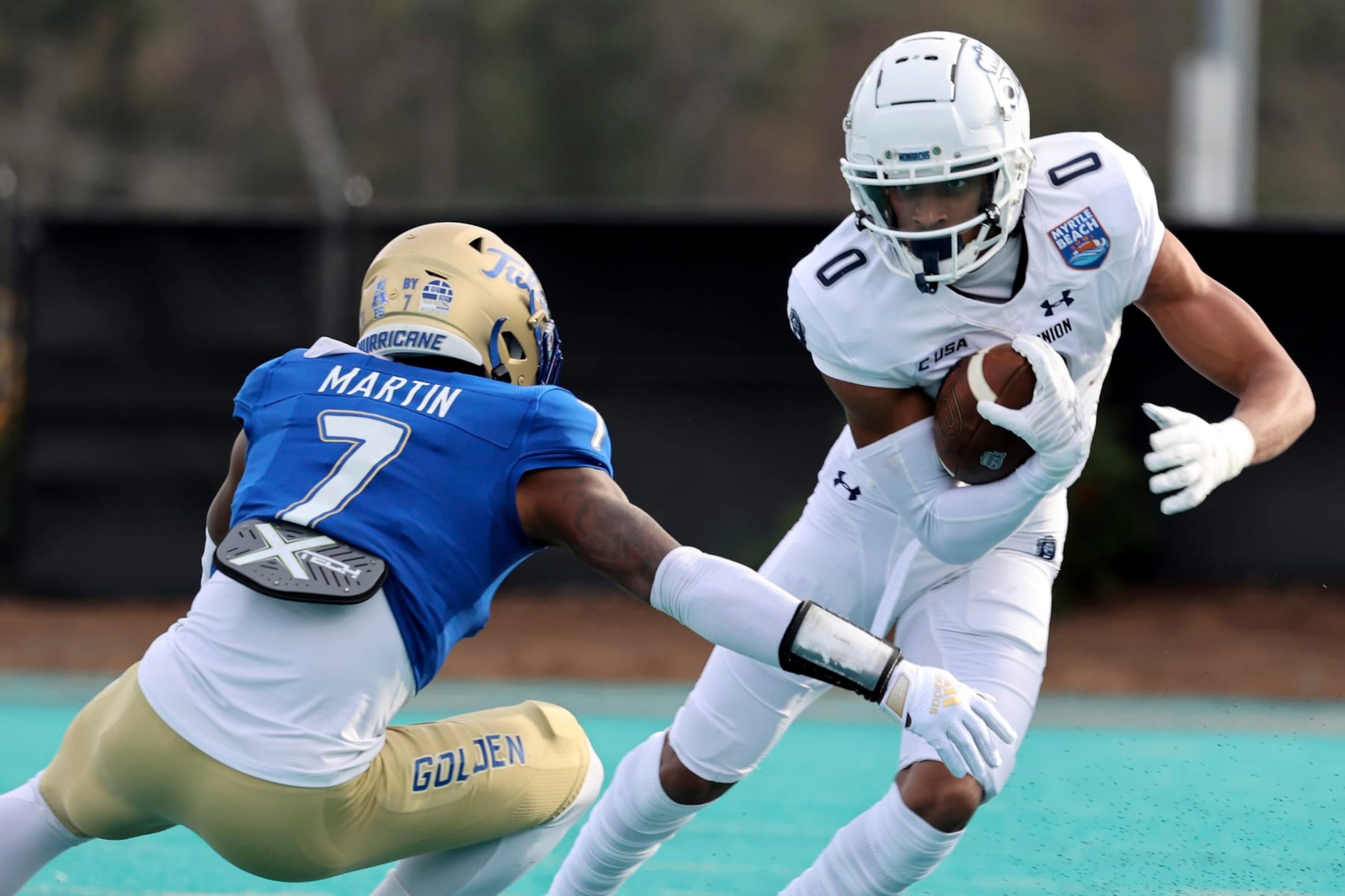 Old Dominion's Ali Jennings III (0) runs the ball against the defense of Tulsa's TieNeal Martin (7) in the first half of an NCAA college football game in the Myrtle Beach Bowl in Conway, S.C., Monday, Dec. 20, 2021. (AP Photo/Mic Smith)