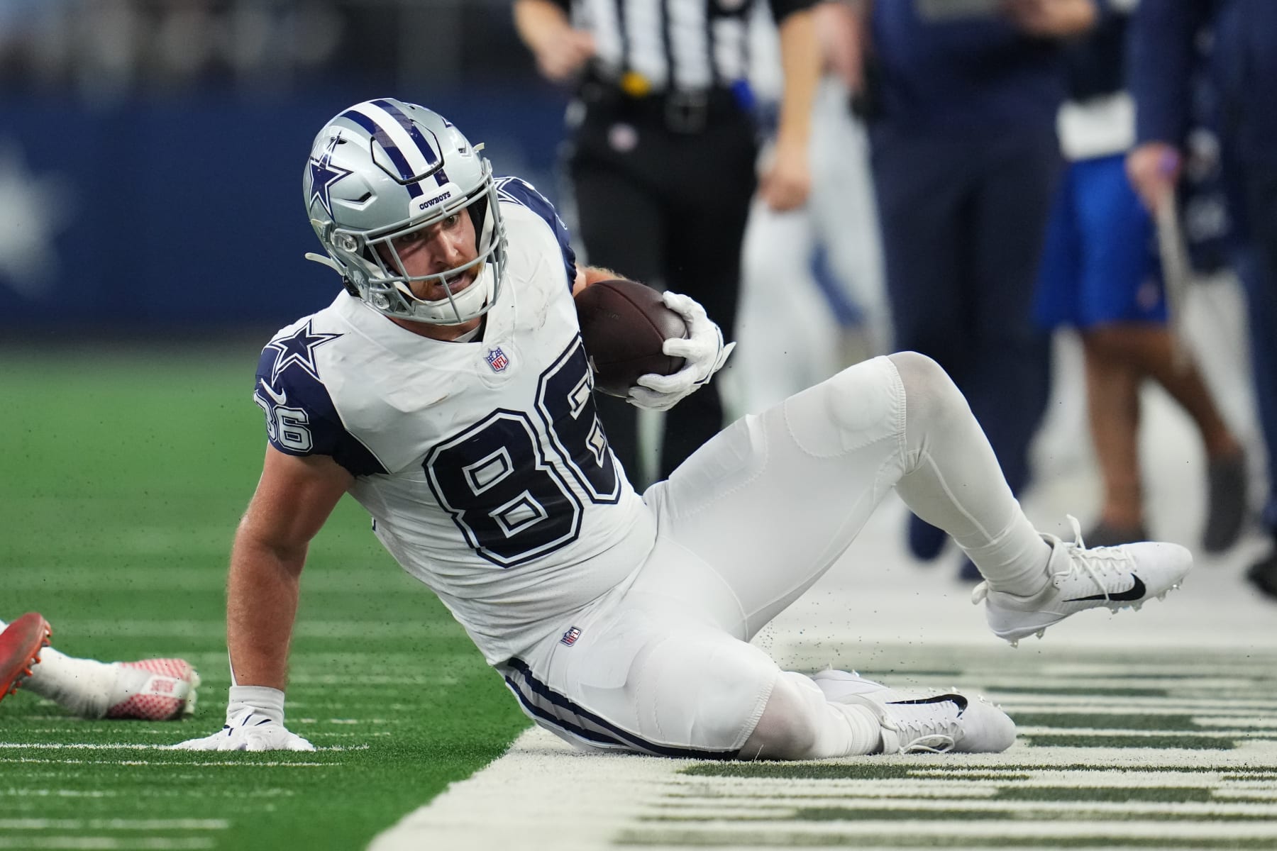 ARLINGTON, TEXAS - JANUARY 02: Dalton Schultz #86 of the Dallas Cowboys slides out of bounds against the Arizona Cardinals during an NFL game at AT&T Stadium on January 02, 2022 in Arlington, Texas. (Photo by Cooper Neill/Getty Images)