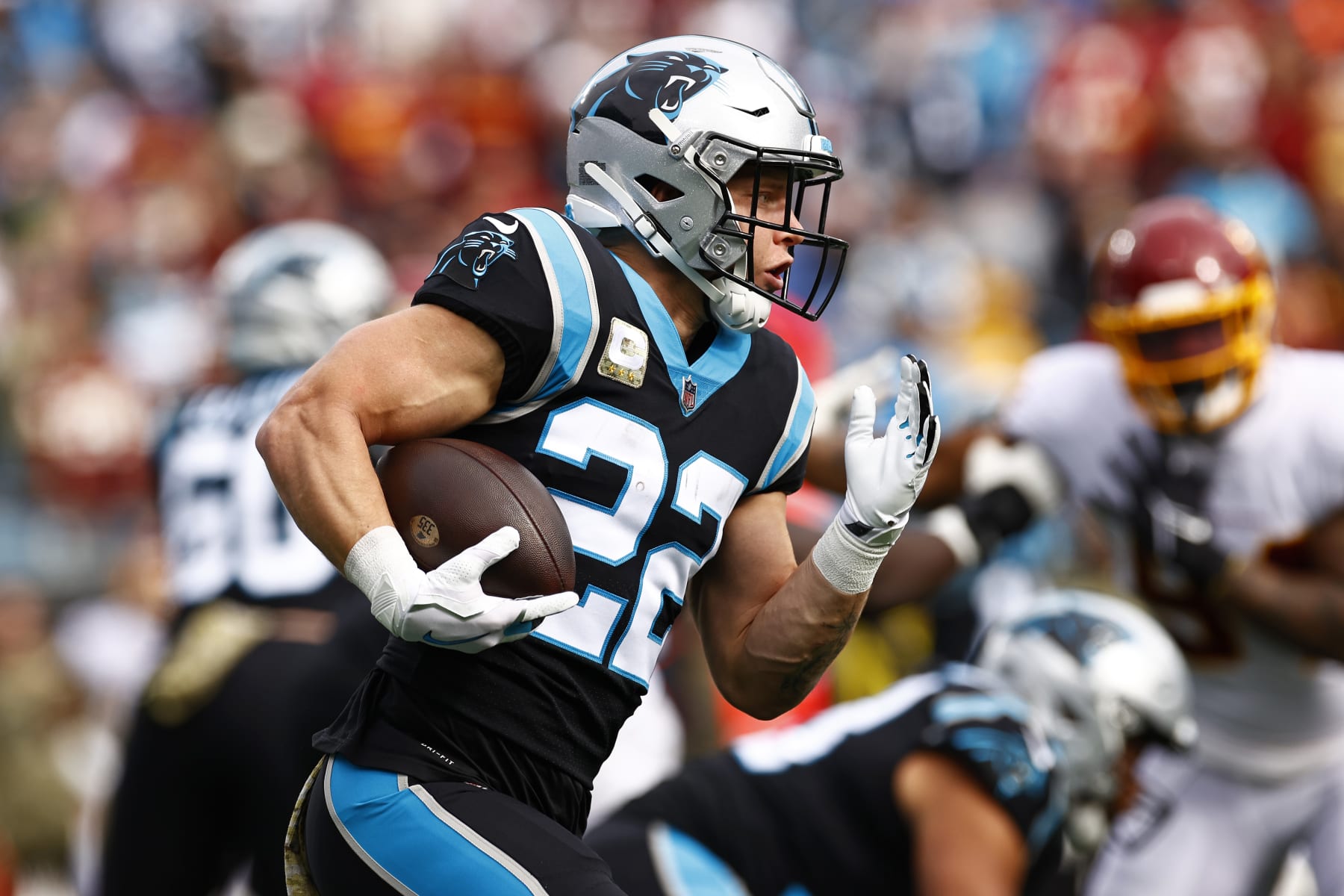 CHARLOTTE, NORTH CAROLINA - NOVEMBER 21: Christian McCaffrey #22 of the Carolina Panthers carries the ball against the defense of the Washington Football Team in the first quarter of the game at Bank of America Stadium on November 21, 2021 in Charlotte, North Carolina. (Photo by Jared C. Tilton/Getty Images)