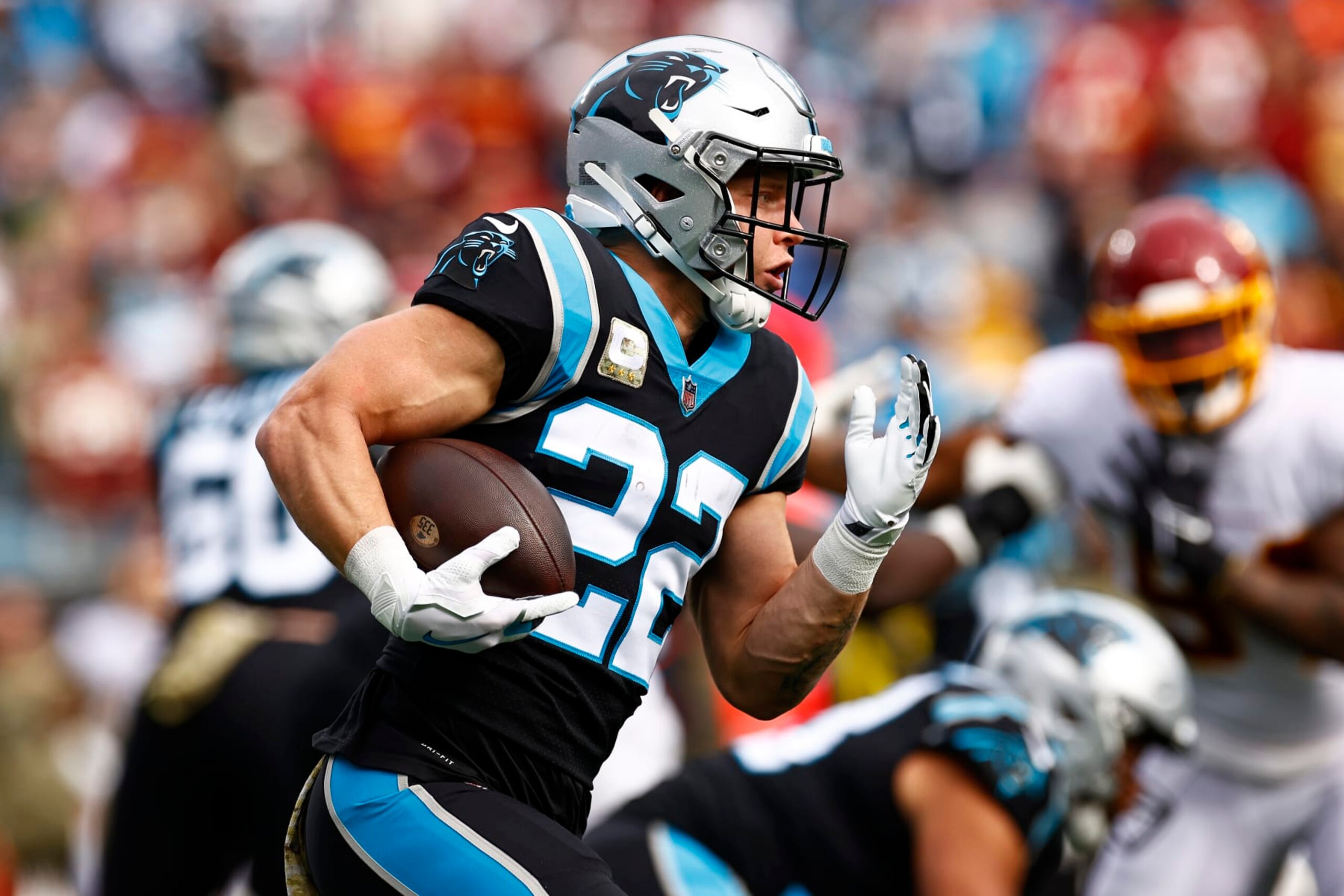 CHARLOTTE, NORTH CAROLINA - NOVEMBER 21: Christian McCaffrey #22 of the Carolina Panthers carries the ball against the defense of the Washington Football Team in the first quarter of the game at Bank of America Stadium on November 21, 2021 in Charlotte, North Carolina. (Photo by Jared C. Tilton/Getty Images)