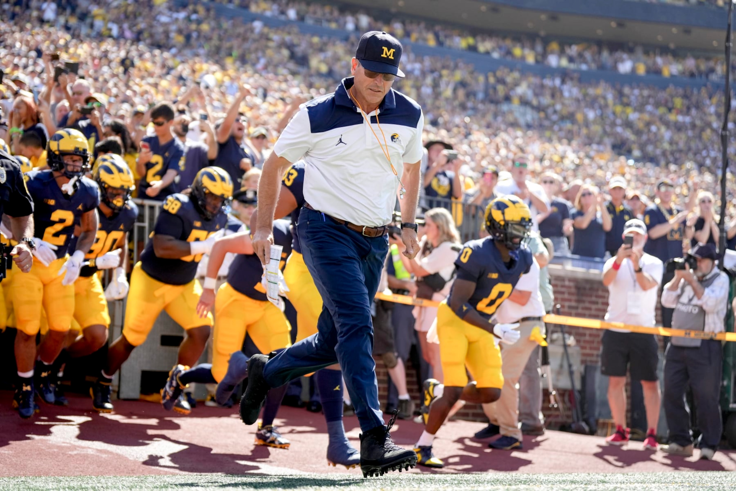 ANN ARBOR, MICHIGAN - SEPTEMBER 03: Head coach Jim Harbaugh of the Michigan Wolverines takes the field with his players before the first half against the Colorado State Rams at Michigan Stadium on September 03, 2022 in Ann Arbor, Michigan. (Photo by Nic Antaya/Getty Images)