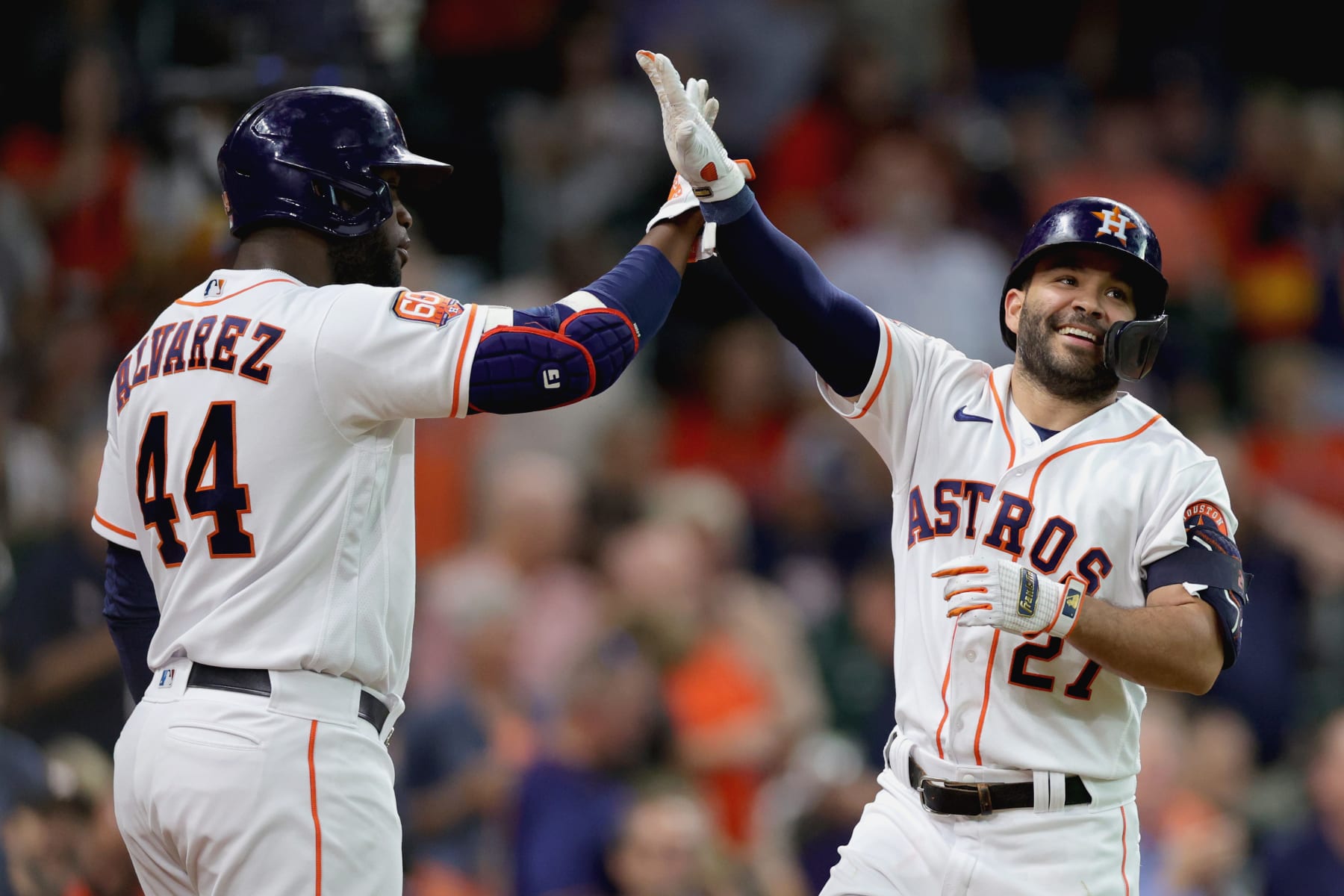 HOUSTON, TEXAS - AUGUST 24: Jose Altuve #27 of the Houston Astros high fives Yordan Alvarez #44 after hitting a solo home run during the first inning against the Minnesota Twins at Minute Maid Park on August 24, 2022 in Houston, Texas. (Photo by Carmen Mandato/Getty Images)