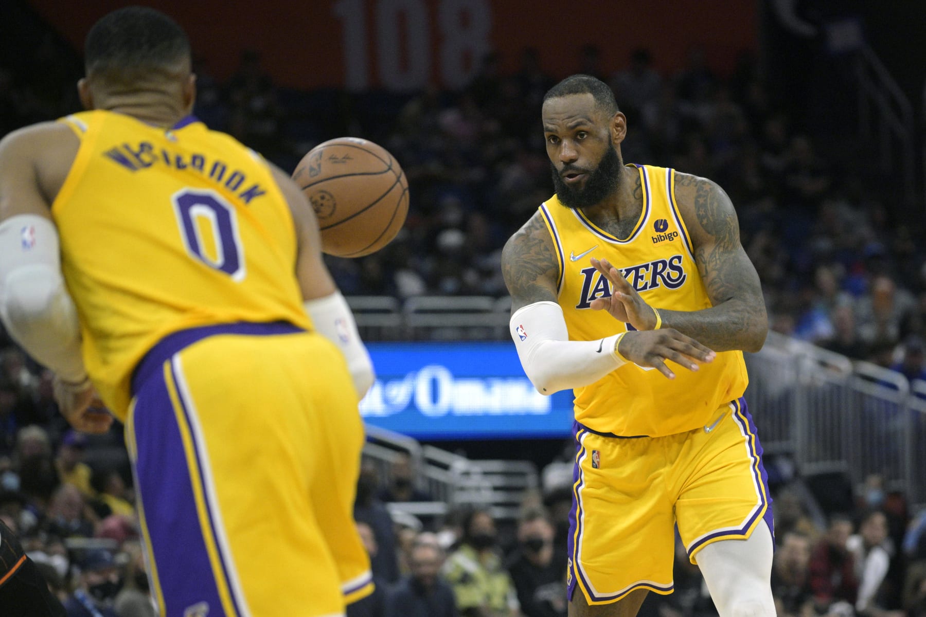 Los Angeles Lakers forward LeBron James, right, passes to guard Russell Westbrook (0) during the first half of an NBA basketball game against the Orlando Magic, Friday, Jan. 21, 2022, in Orlando, Fla. (AP Photo/Phelan M. Ebenhack)