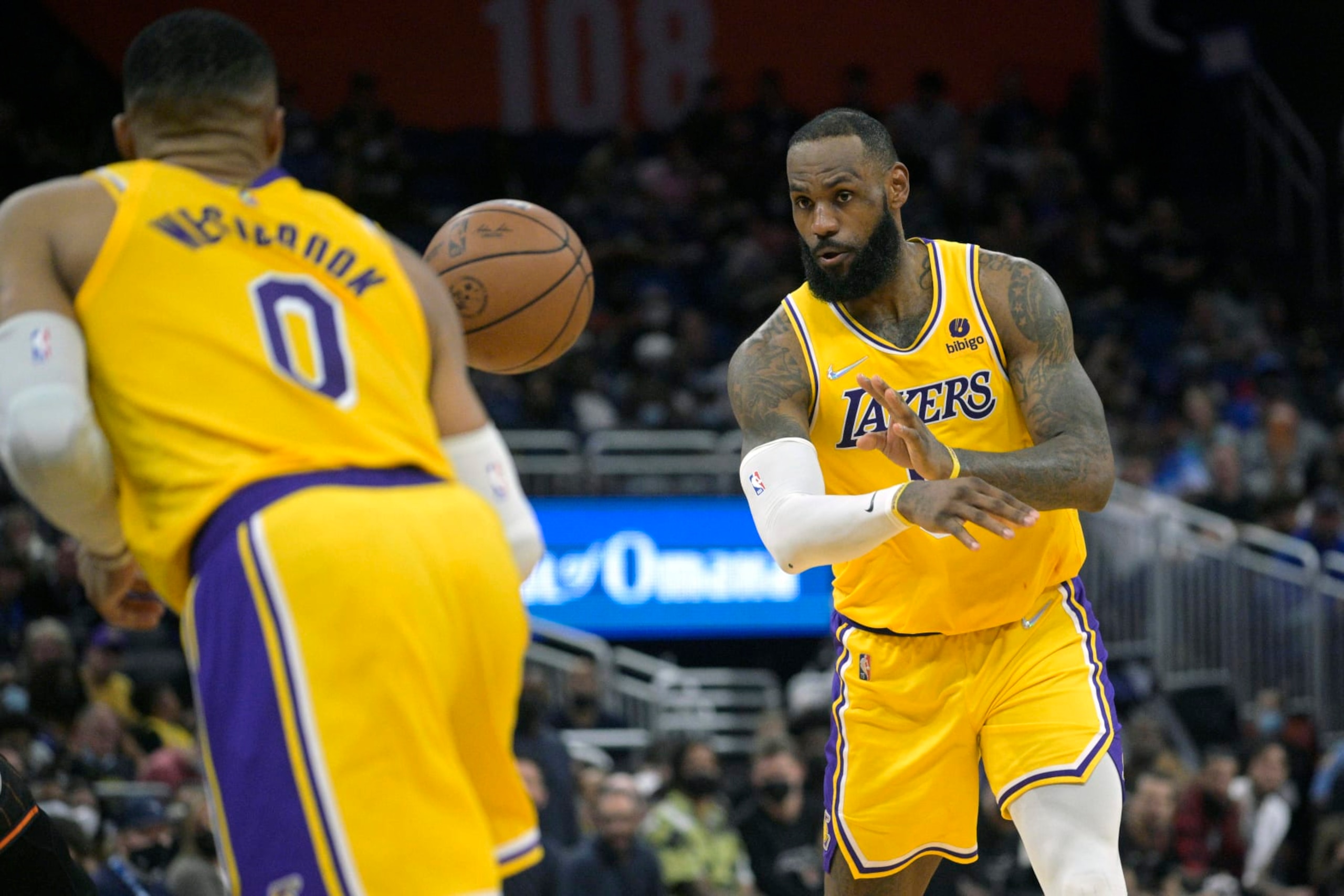 Los Angeles Lakers forward LeBron James, right, passes to guard Russell Westbrook (0) during the first half of an NBA basketball game against the Orlando Magic, Friday, Jan. 21, 2022, in Orlando, Fla. (AP Photo/Phelan M. Ebenhack)