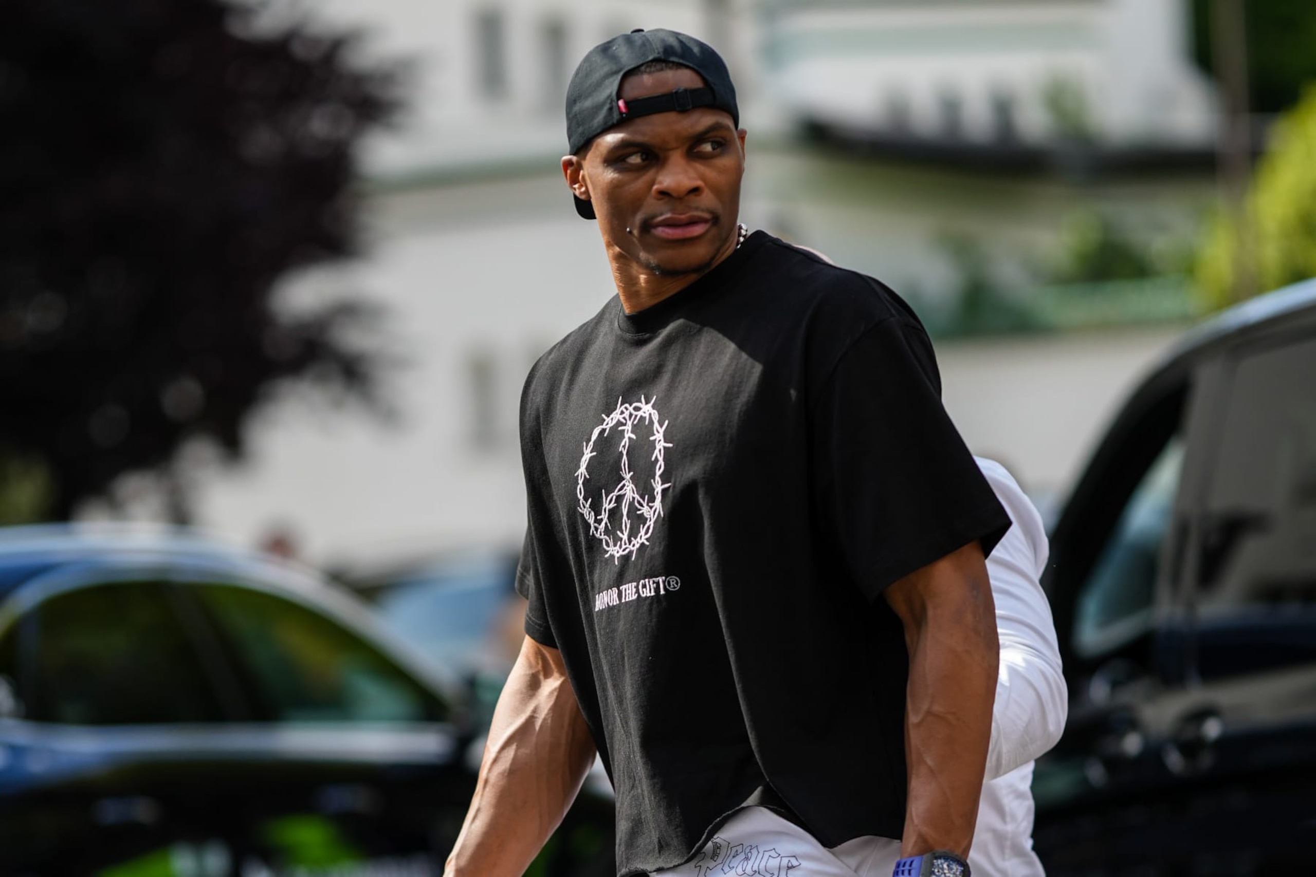 PARIS, FRANCE - JUNE 23: Russell Westbrook wears a black cap, a silver pearls necklace, a black with white print pattern t-shirt, a blue and gray watch, a diamonds rings, white with embroidered black pattern denim jeans pants, outside the Amiri show, during Paris Fashion Week - Menswear Spring/Summer 2023, on June 23, 2022 in Paris, France. (Photo by Edward Berthelot/Getty Images) PARIS, FRANCE - JUNE 23: Russell Westbrook wears a black cap, a silver pearls necklace, a black with white print pattern t-shirt, a blue and gray watch, a diamonds rings, white with embroidered black pattern denim jeans pants, outside the Amiri show, during Paris Fashion Week - Menswear Spring/Summer 2023, on June 23, 2022 in Paris, France. (Photo by Edward Berthelot/Getty Images)