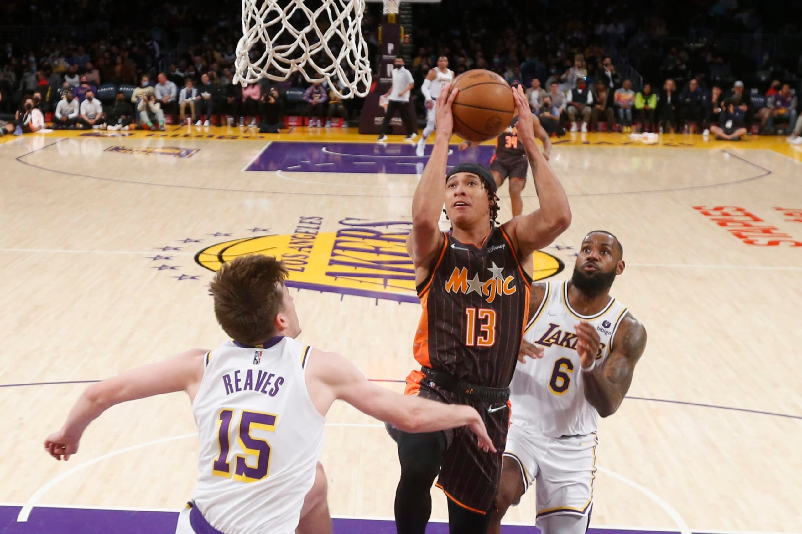 Orlando Magic guard R.J. Hampton (13) drives to basket between Los Angeles Lakers guard Austin Reaves (15) and forward LeBron James (6) during the first half of an NBA basketball game in Los Angeles, Sunday, Dec. 12, 2021. (AP Photo/Ringo H.W. Chiu)