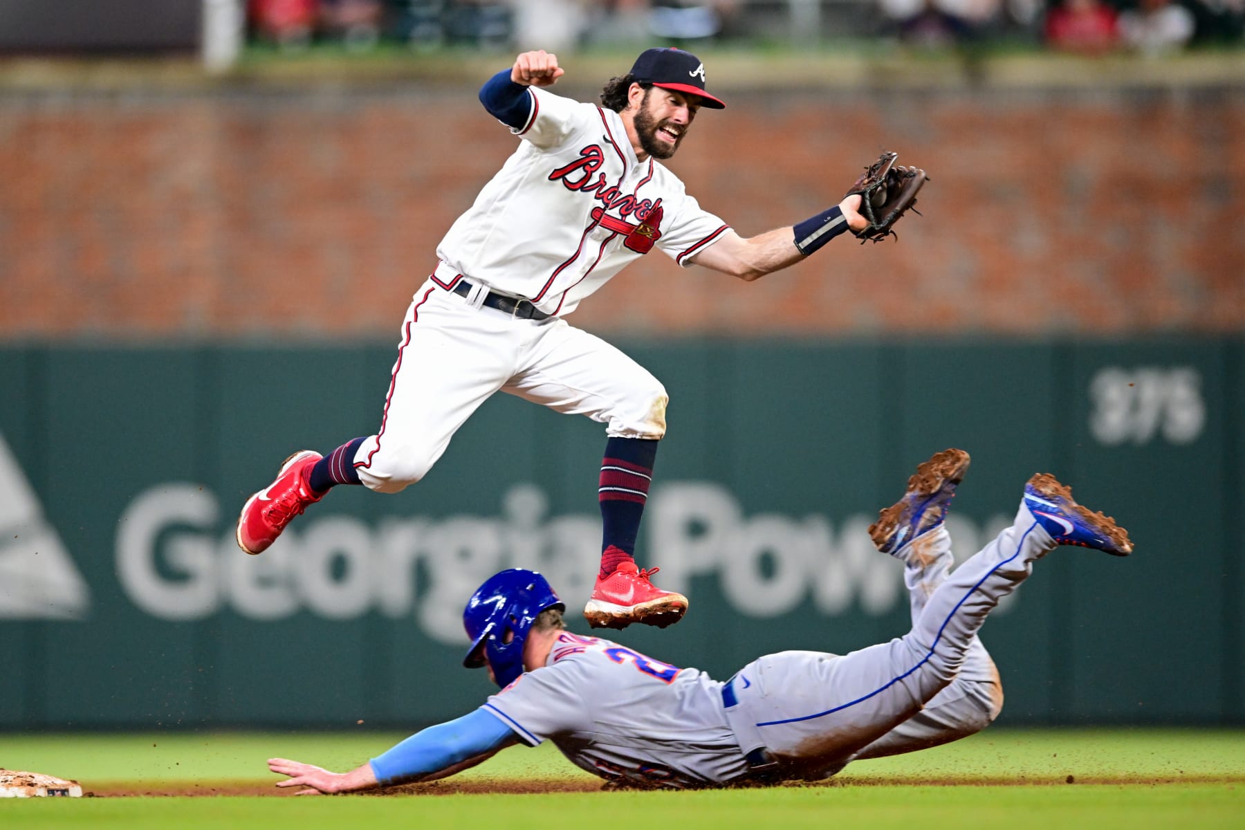 ATLANTA, GA - AUGUST 17: Pete Alonso #20 of the New York Mets slides under Dansby Swanson #7 of the Atlanta Braves during the ninth inning at Truist Park on August 17, 2022 in Atlanta, Georgia. (Photo by Adam Hagy/Getty Images)