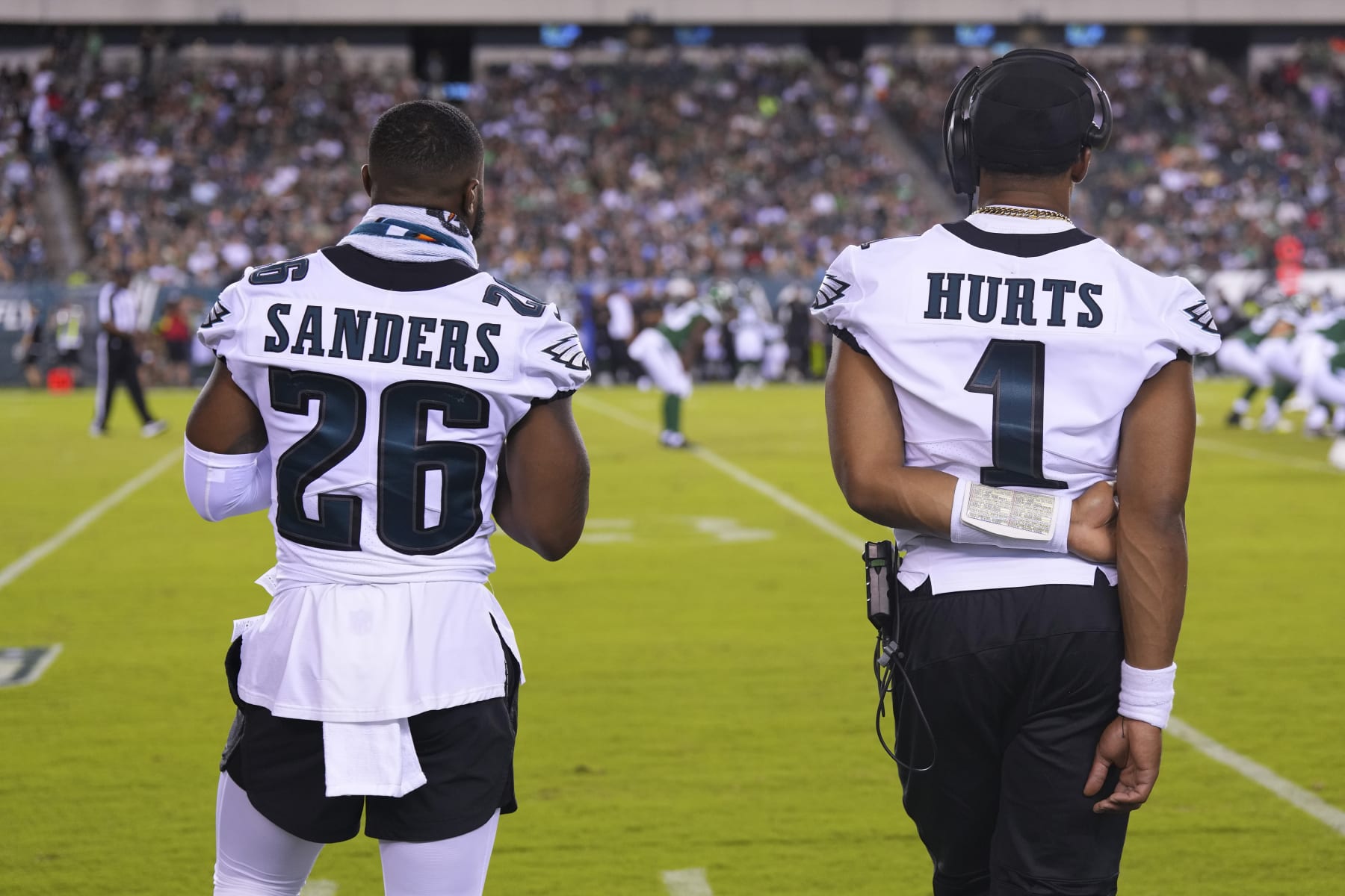 PHILADELPHIA, PA - AUGUST 12: Miles Sanders #26 and Jalen Hurts #1 of the Philadelphia Eagles look on from the sidelines against the New York Jets in the second half of the preseason game at Lincoln Financial Field on August 12, 2022 in Philadelphia, Pennsylvania. The Jets defeated the Eagles 24-21. (Photo by Mitchell Leff/Getty Images)