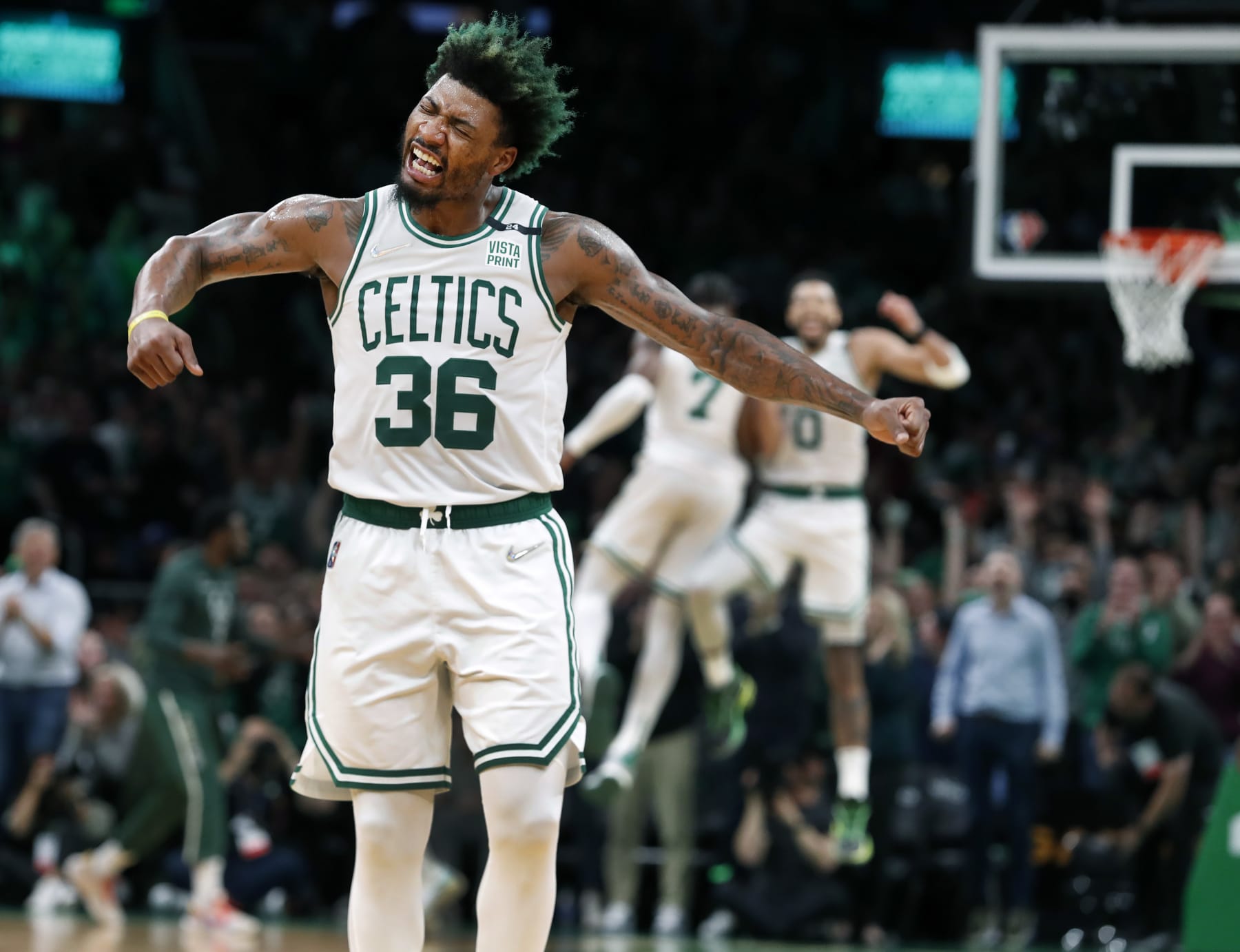Boston - May 11: The Celtics Marcus Smart erupts in celebration after his teammate Jayson Tatum (0, back-round right) slammed home two second quarter points to put Boston ahead 51-38. Tatum is celebrating himself with teammate Jaylen Brown (7) in the background. The Boston Celtics host the Milwaukee Bucks in Game 5 of the Eastern Conference semi-finals between the Celtics and Bucks on May 11, 2022 at TD Garden in Boston. (Photo by Jim Davis/The Boston Globe via Getty Images)
