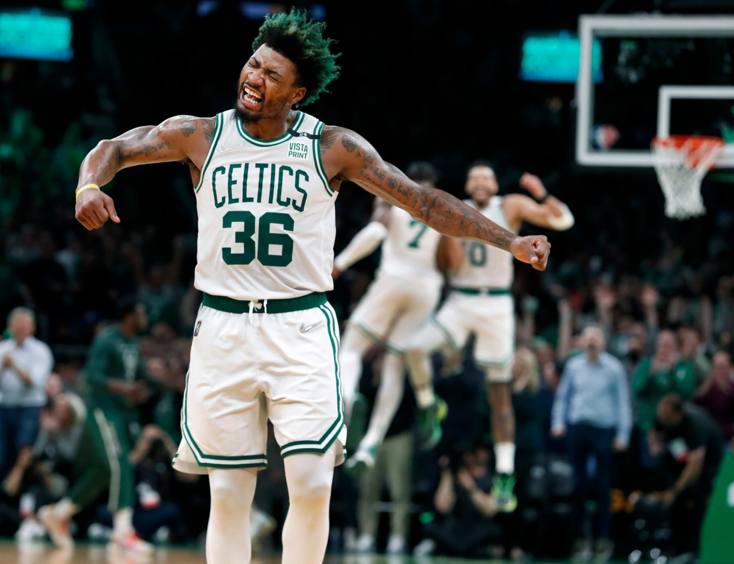 Boston - May 11: The Celtics Marcus Smart erupts in celebration after his teammate Jayson Tatum (0, back-round right) slammed home two second quarter points to put Boston ahead 51-38. Tatum is celebrating himself with teammate Jaylen Brown (7) in the background. The Boston Celtics host the Milwaukee Bucks in Game 5 of the Eastern Conference semi-finals between the Celtics and Bucks on May 11, 2022 at TD Garden in Boston. (Photo by Jim Davis/The Boston Globe via Getty Images)