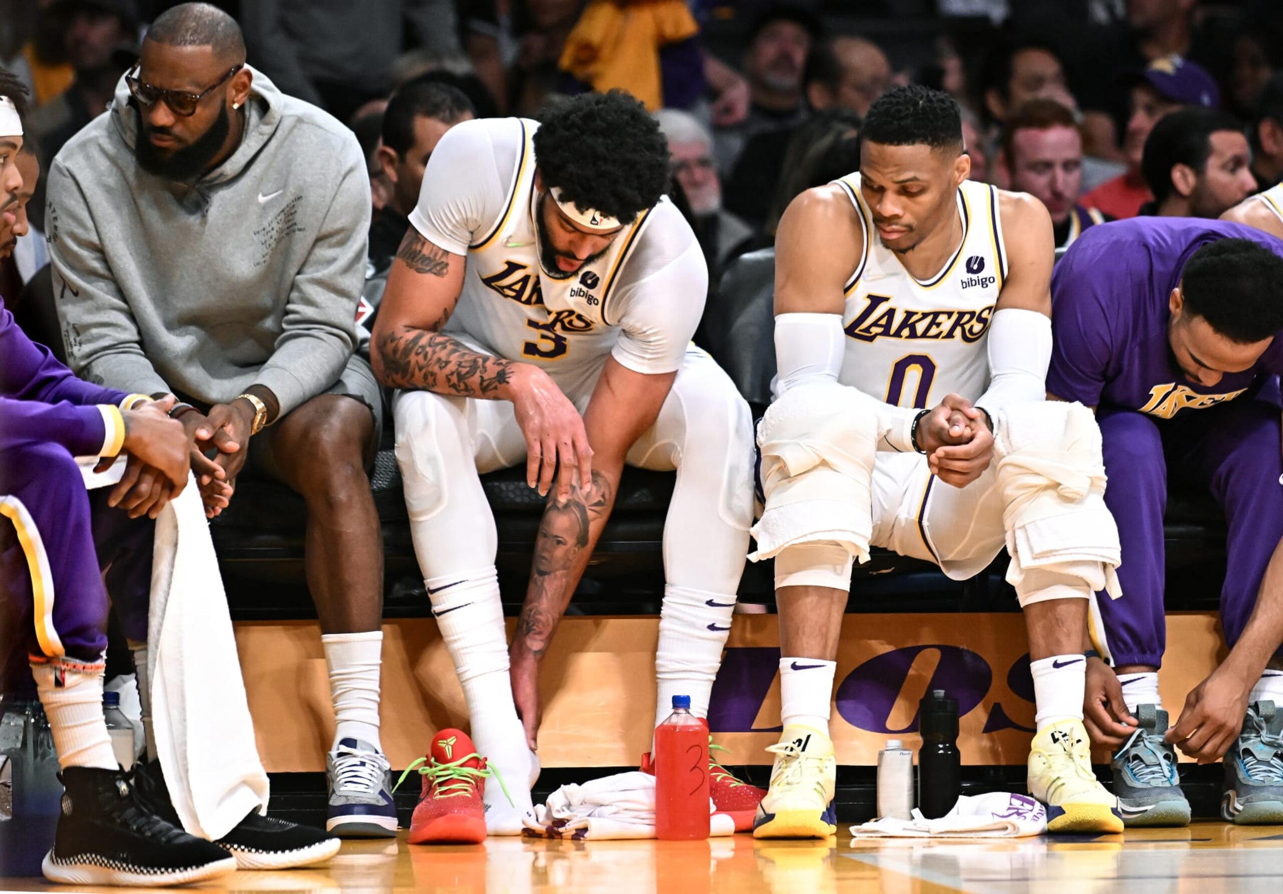 Los Angeles, California April 3, 2022- Lakers Anthony Davis, center, hold this ankle as LeBron James, let, and Russell Westbrook sit next to him against the Nuggets at Crypto.com Arena Sunday. (Wally Skalij/Los Angeles Times via Getty Images)