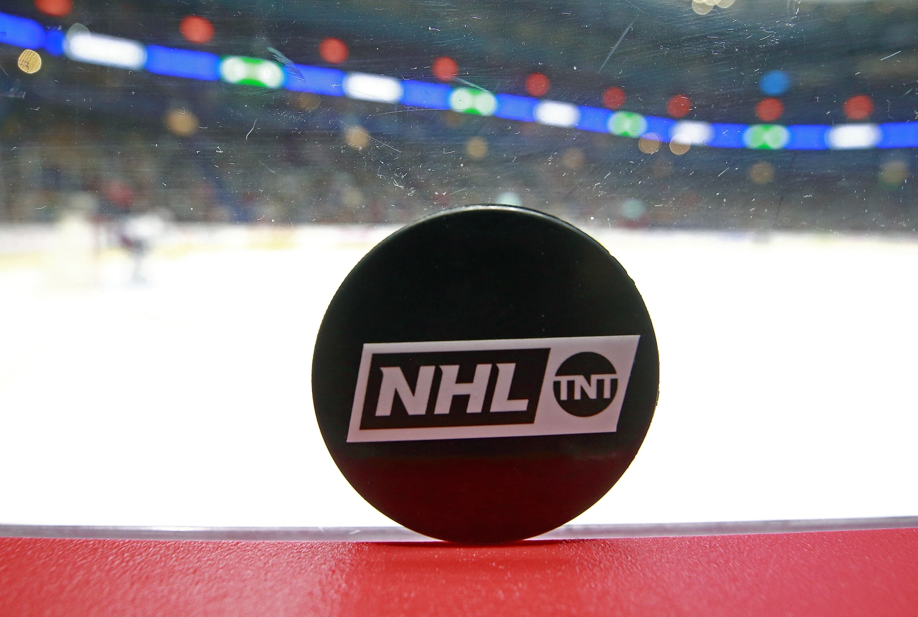 VANCOUVER, BC - FEBRUARY 09: A TNT puck sits on the boards during the NHL game between the New York Islanders and the Vancouver Canucks at Rogers Arena February 9, 2022 in Vancouver, British Columbia, Canada.  (Photo by Jeff Vinnick/NHLI via Getty Images)"n